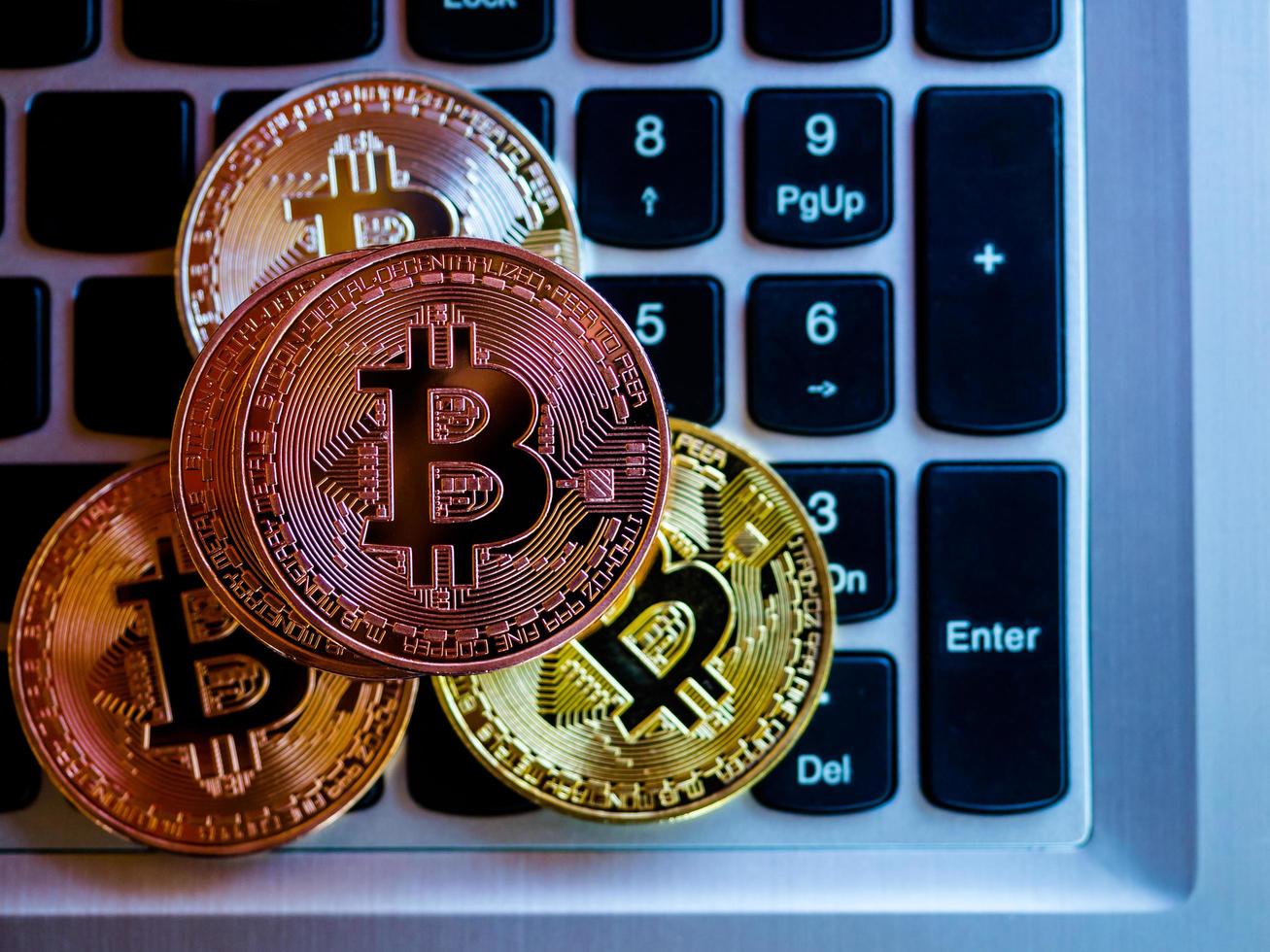 Bitcoins sind Kupfer, Gold und Silber, die in der digitalen Währung enthalten sind. auf einem Tastaturhintergrund foto