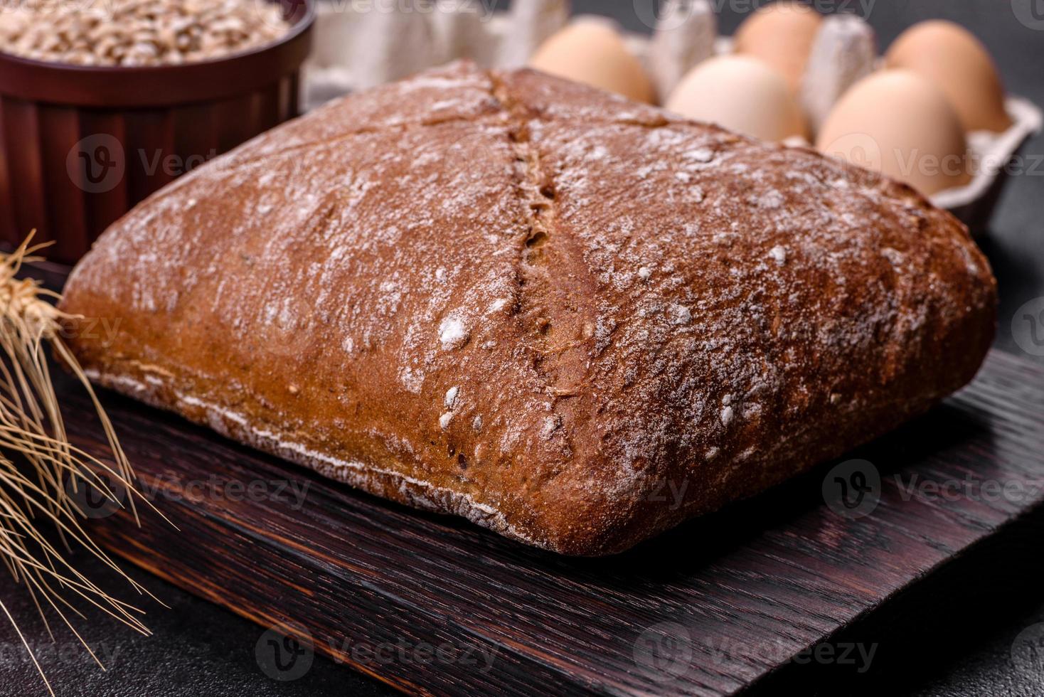 schönes leckeres, quadratisches braunes brot auf einem dunklen betonhintergrund foto