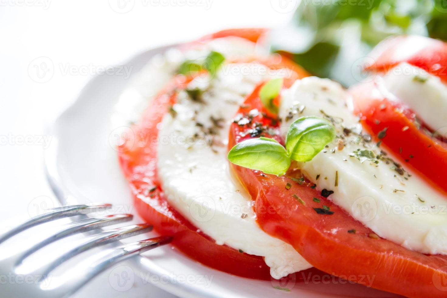 Caprese-Salat, weißer Teller, weißer Holzhintergrund foto