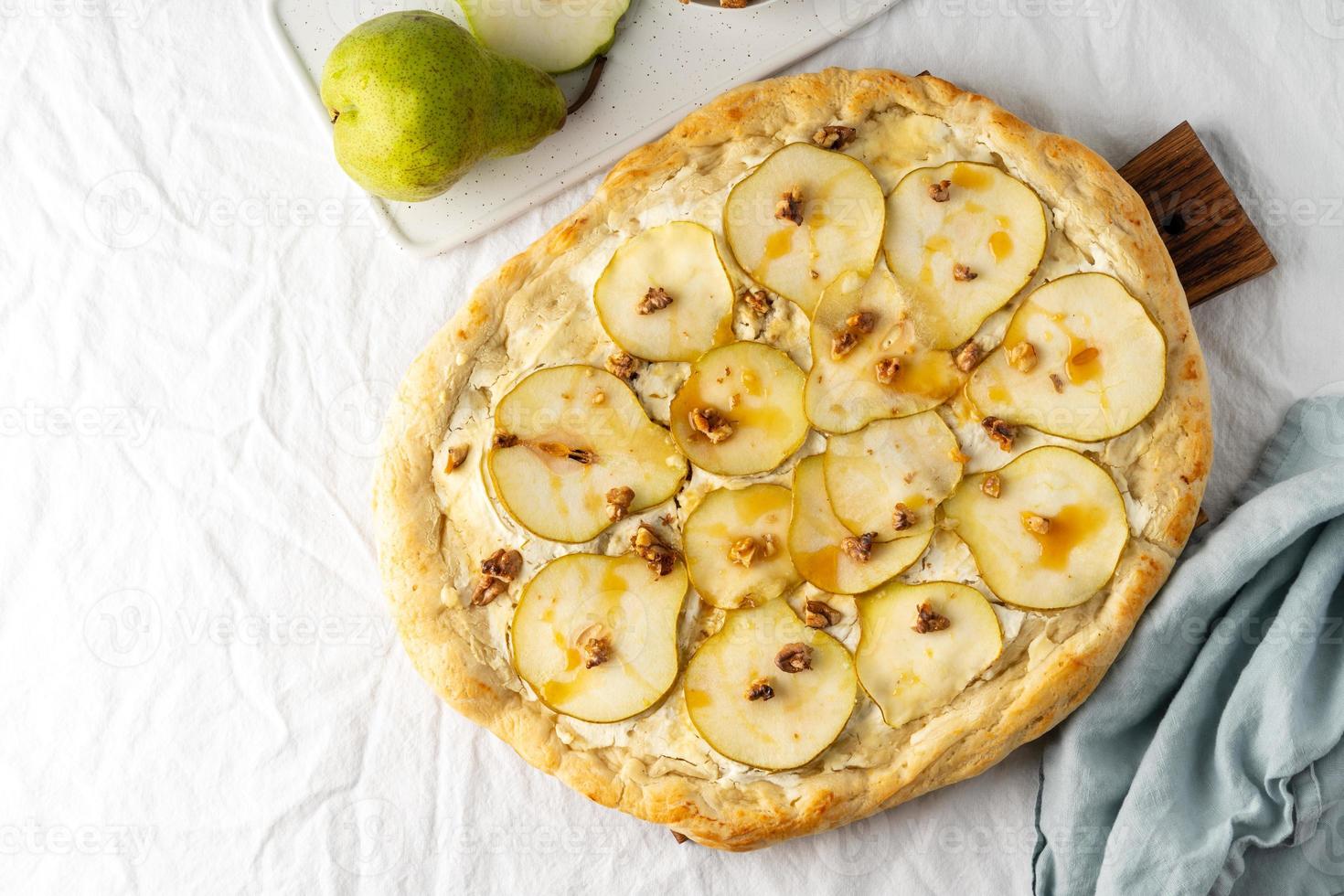 obst hausgemachte birnenpizza mit käse und honig, rustikales italienisches schmackhaftes essen mit gebäckteig foto