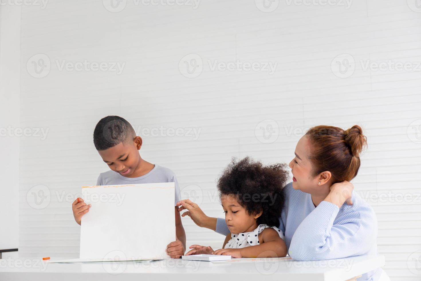 großmutter und enkel spielen fröhlich im wohnzimmer, kinder und großeltern malen zusammen bilder, junge zeigt sein bild foto