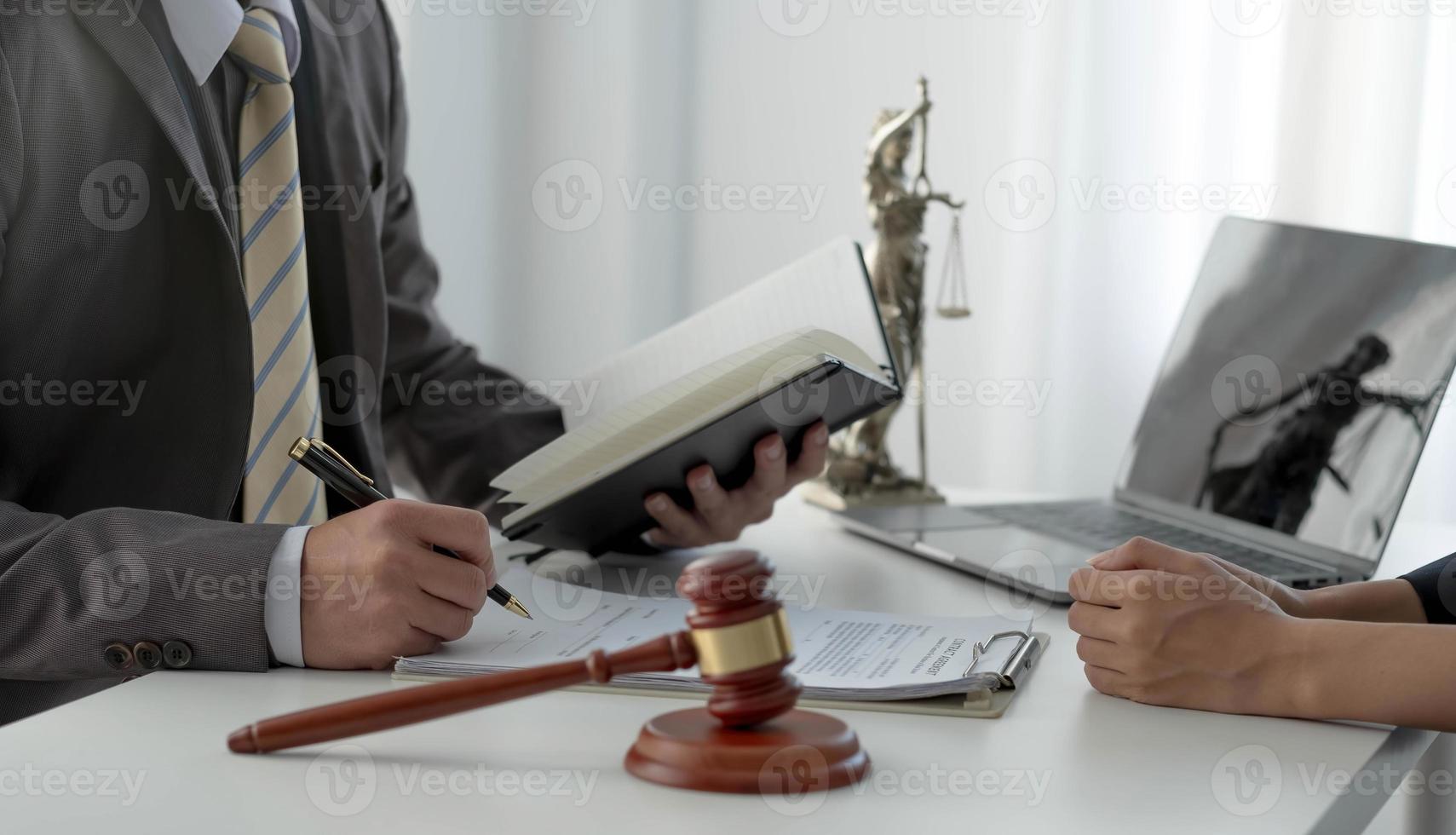 Geschäftsfrau und Anwälte diskutieren Vertragspapiere mit Messingwaage auf Holzschreibtisch im Büro. recht, juristische dienstleistungen, beratung, justizkonzept. foto