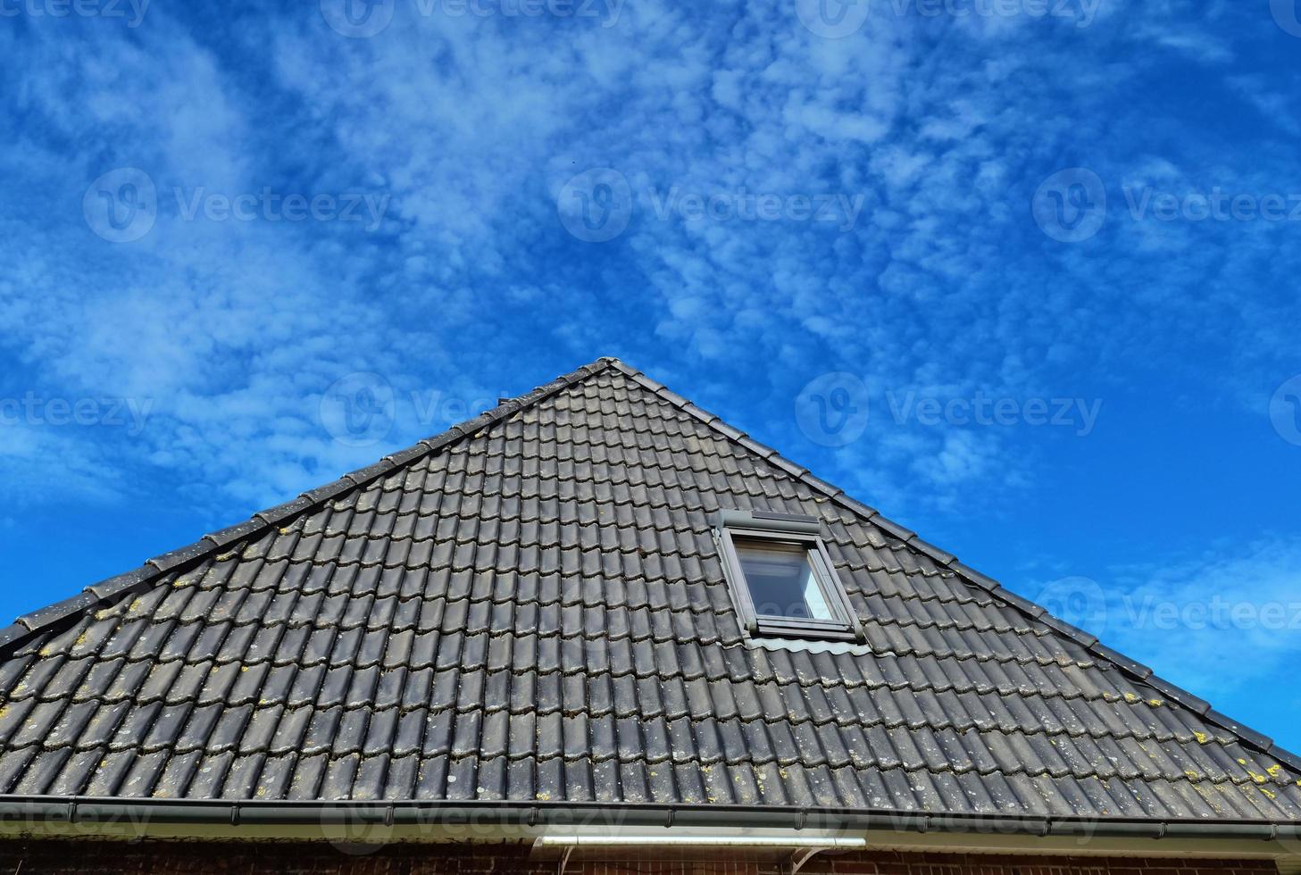 offenes dachfenster im velux-stil mit schwarzen dachziegeln. foto