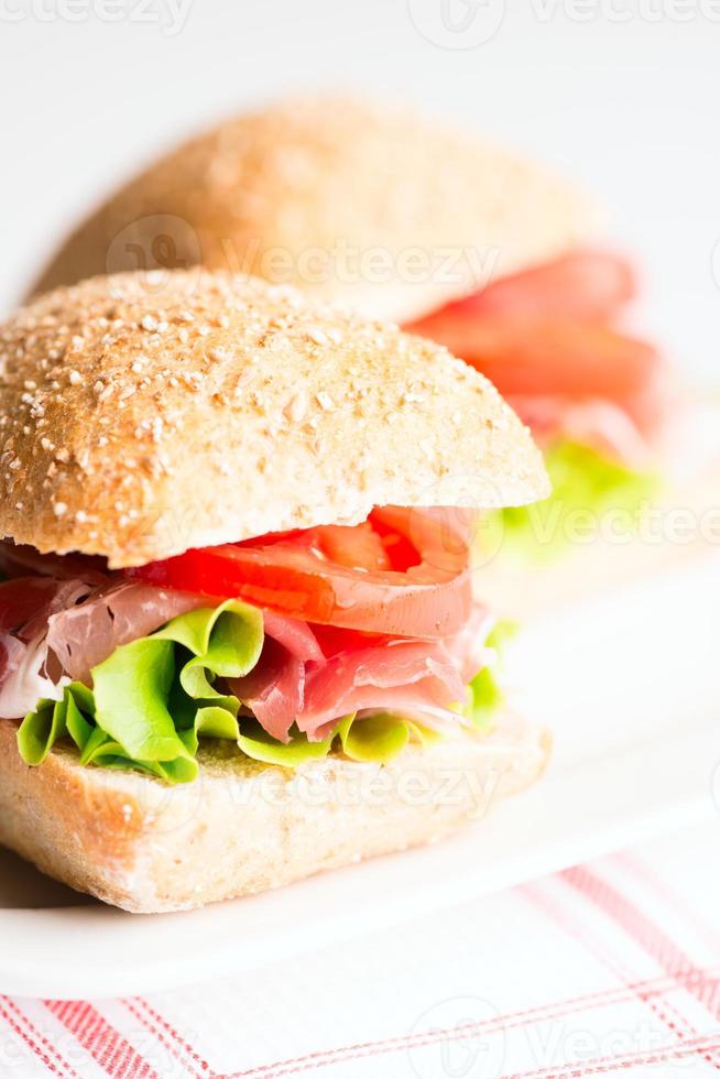 Schinken-Sandwich mit selektivem Fokus auf Tomaten und Rucola foto
