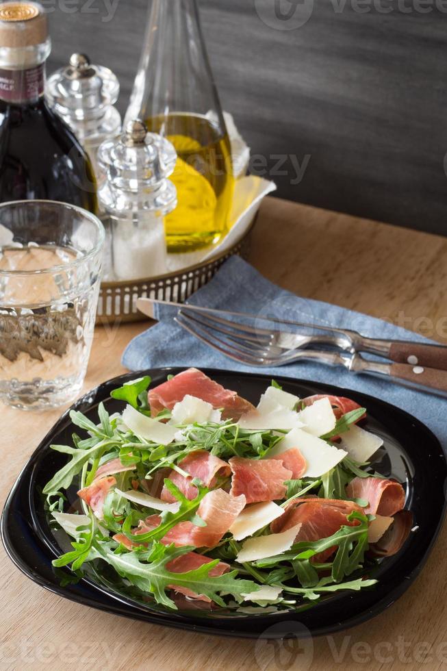Rucola-Salat mit rasiertem Parmesan und Schinken-Crudo foto