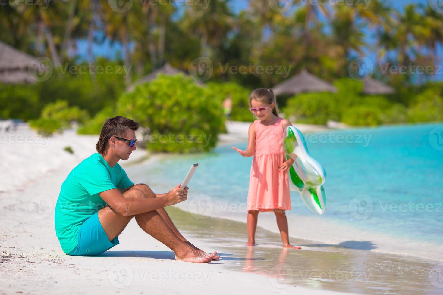 kleines trauriges Mädchen, das darauf wartet, dass Papa schwimmt, bis er arbeitet foto