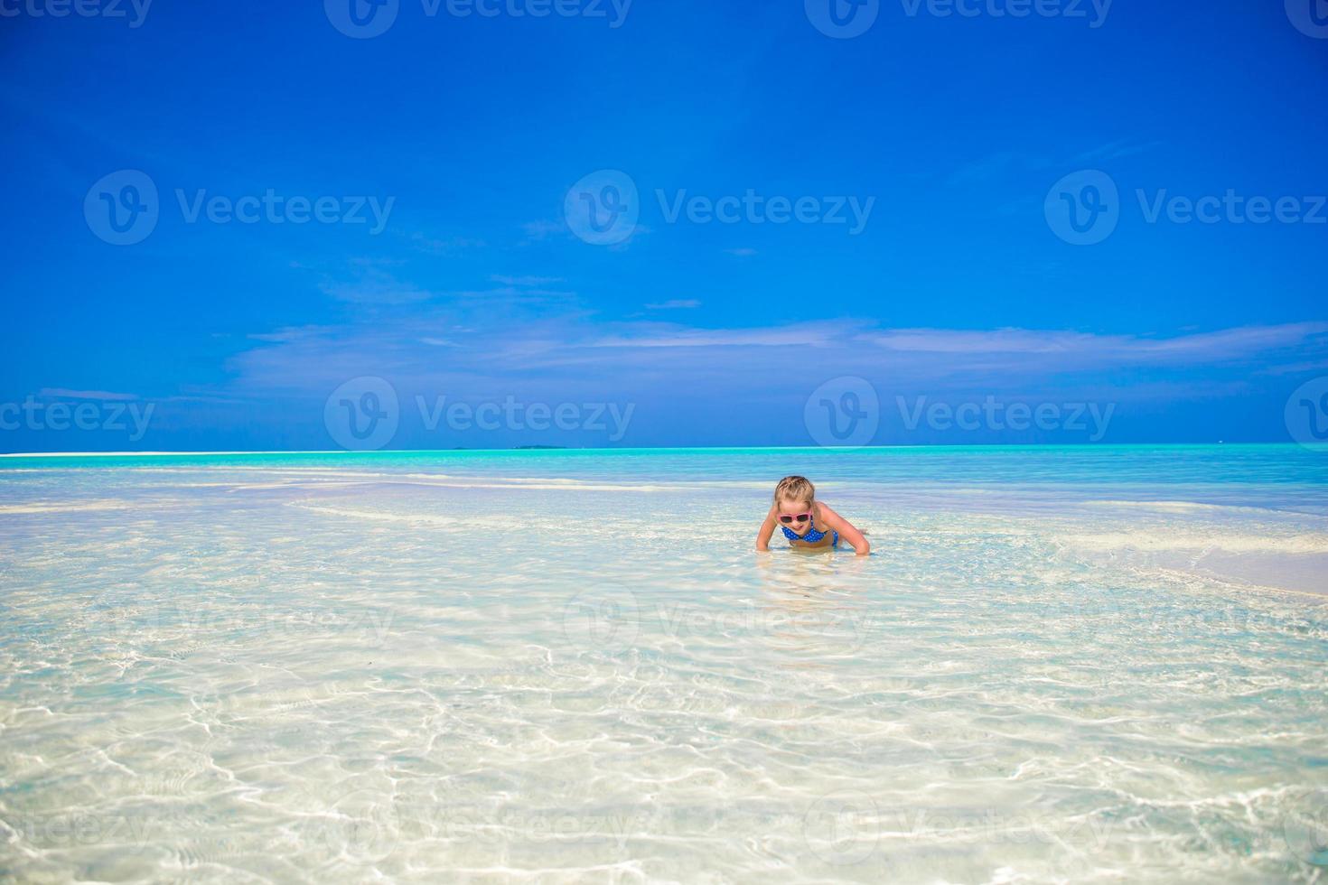 entzückendes kleines Mädchen am Strand während der Sommerferien foto