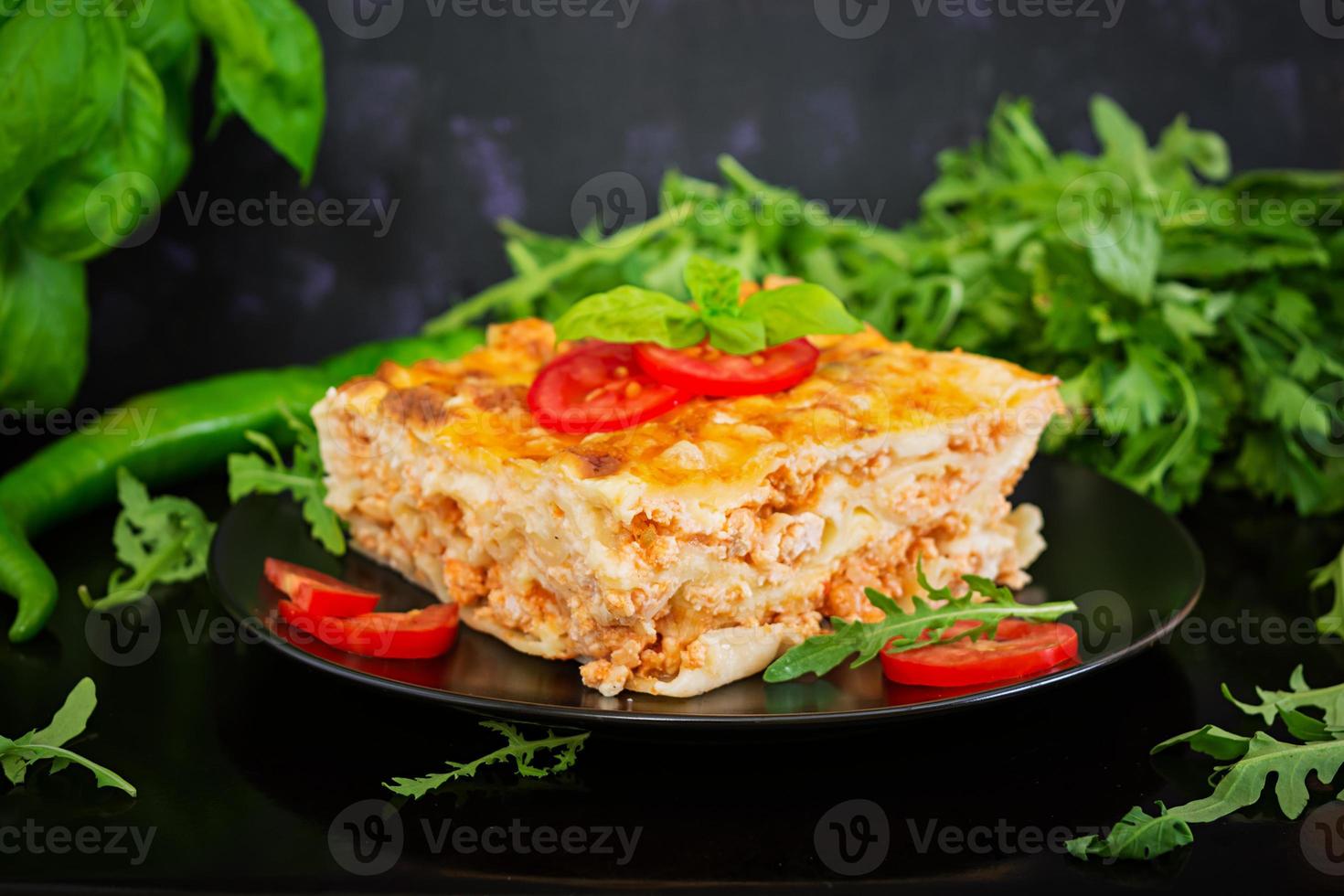 klassische Lasagne mit Bolognese-Sauce auf dunklem Hintergrund foto