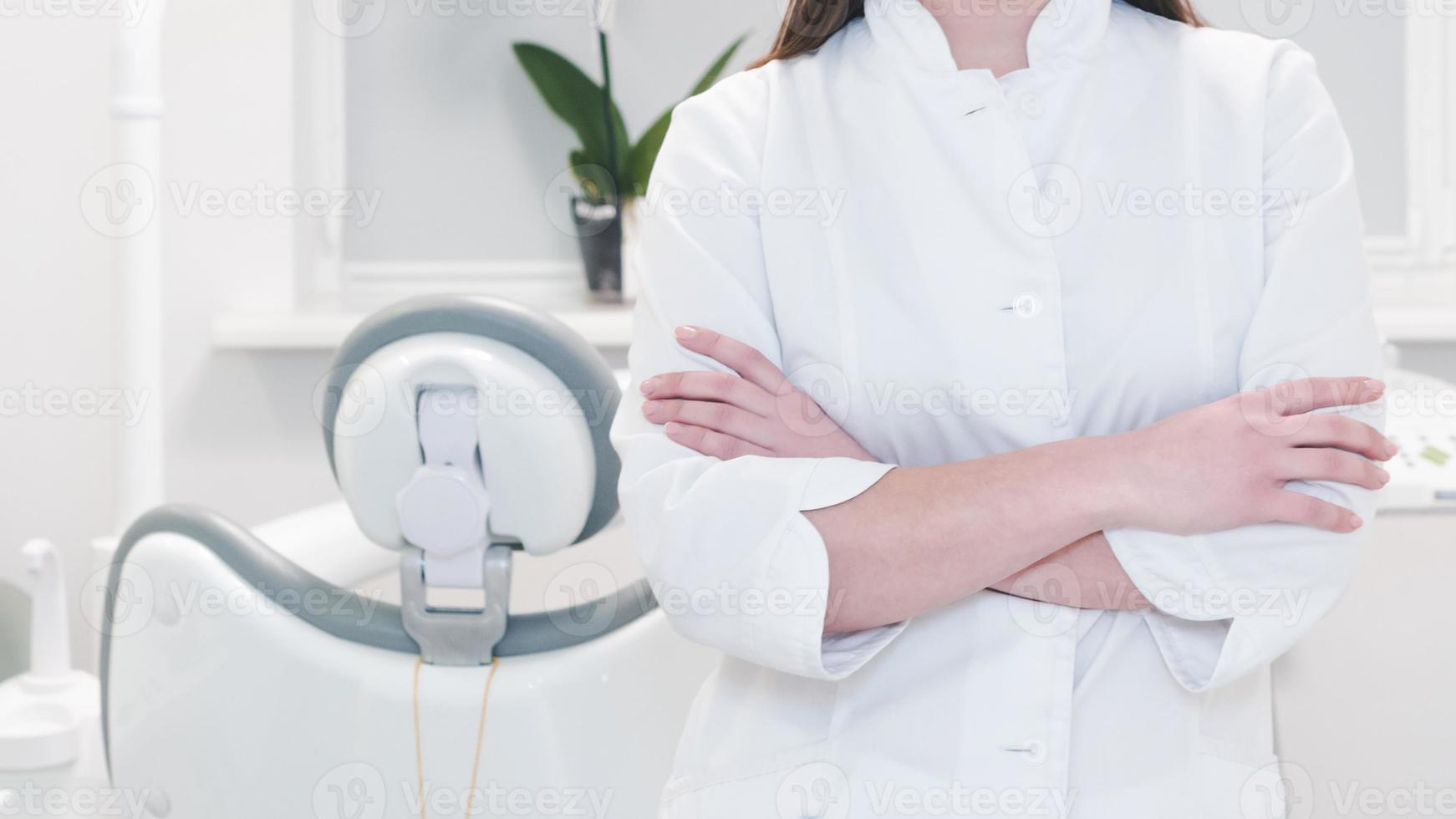 Porträt einer Zahnärztin in weißer Uniform am Arbeitsplatz, Nahaufnahme. foto