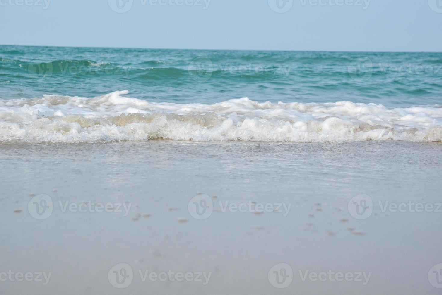 Weitwinkelaufnahme von Meerwasser, das auf den Strand trifft, weißer Schwamm des Meeres, Sommernatur-Hintergrundbildkonzept. foto