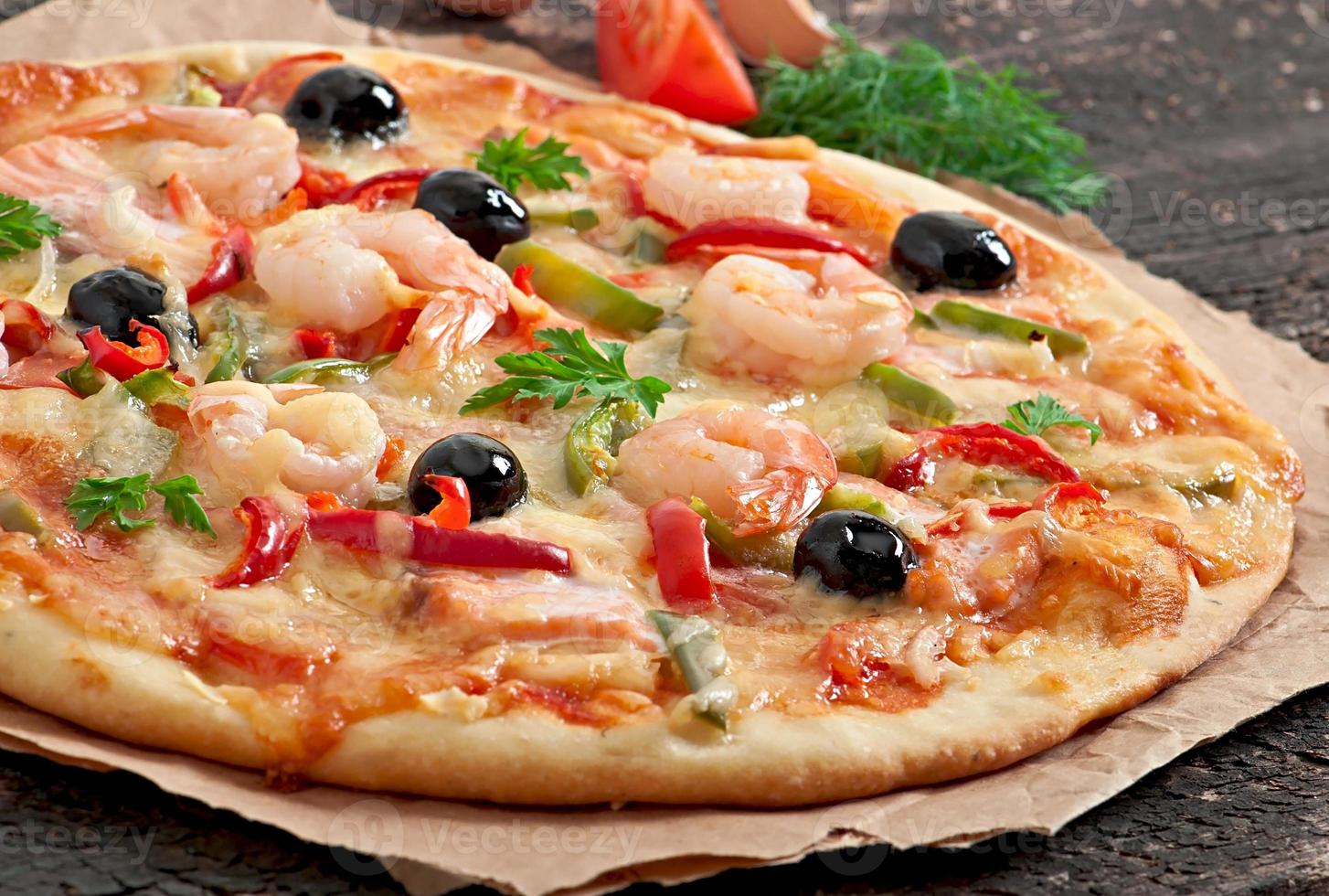 Pizza mit Garnelen, Lachs und Oliven foto