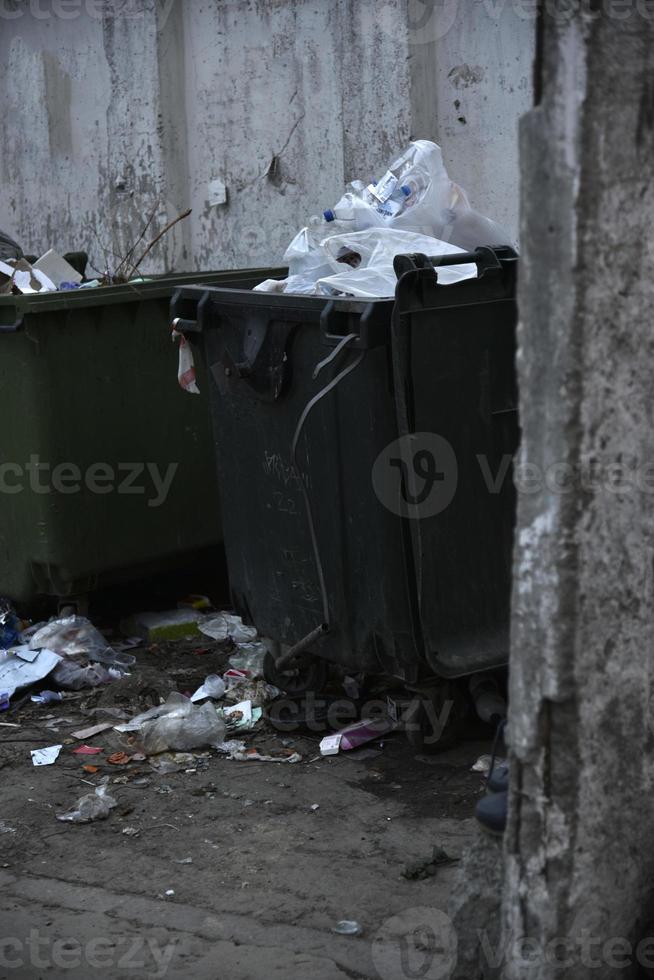 Müllcontainer und Säcke mit Müll auf der Straße foto