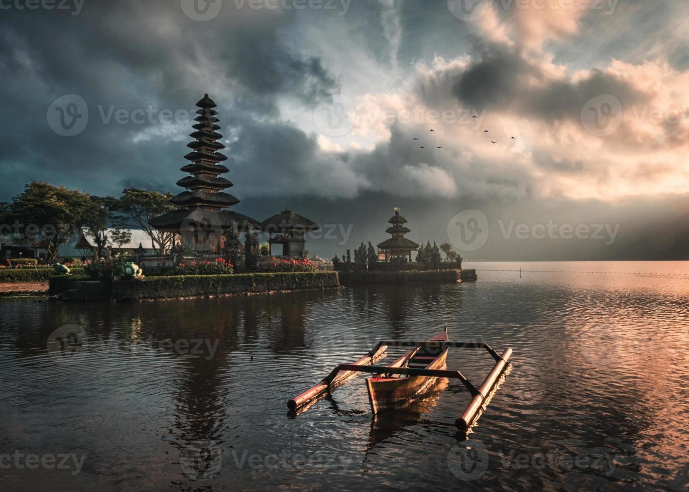 alter tempel von pura ulun danu bratan mit traditionellem boot auf bratan see bei sonnenaufgang in bali foto