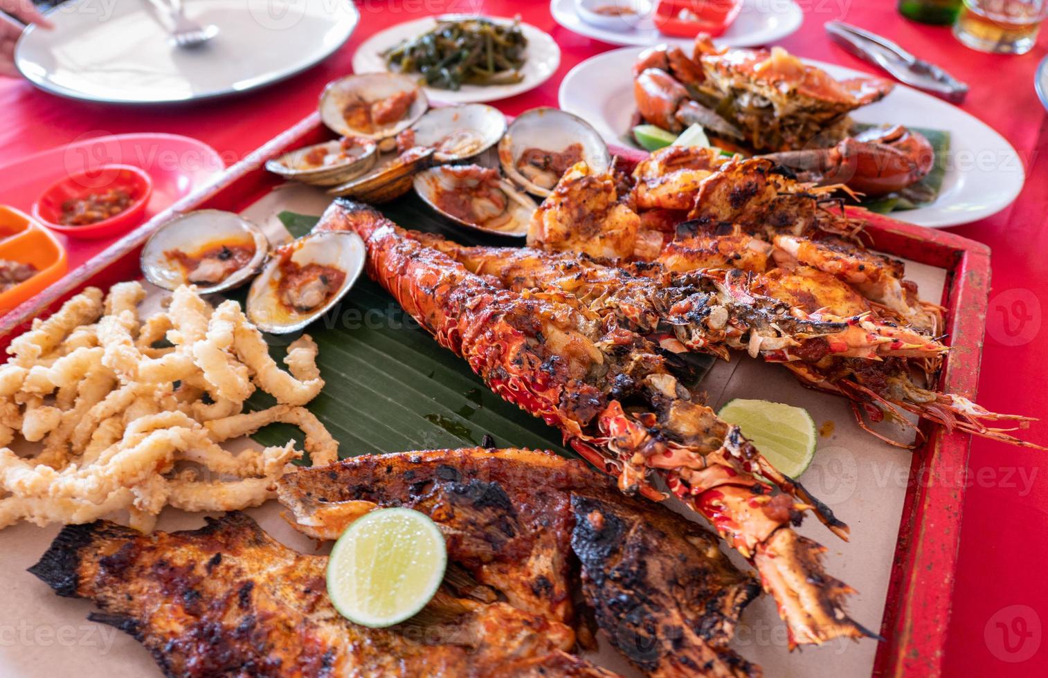 Meeresfrüchte-Set mit Hummer, Krabben, Fisch, Garnelen, Schalentieren auf Holztablett im Restaurant foto