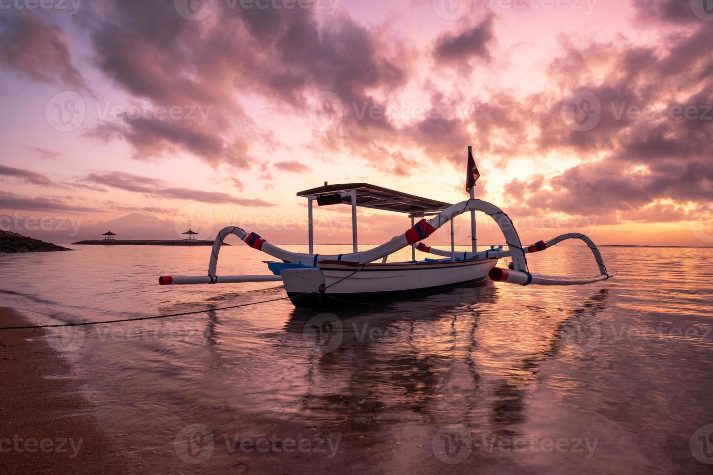 altes traditionelles janggolan-fischerboot an der küste bei buntem sonnenaufgang foto