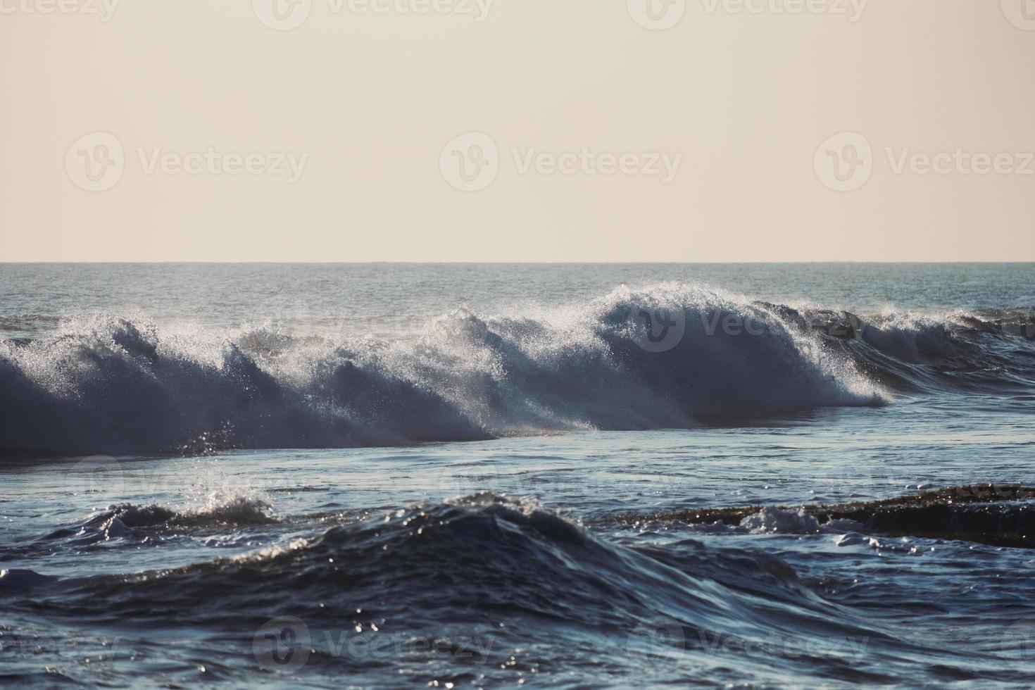 Welle, die an der Küste im tropischen Meer spritzt foto
