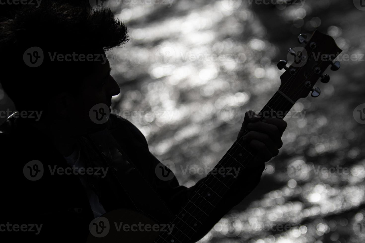 Silhouette eines Jungen mit Gitarre foto