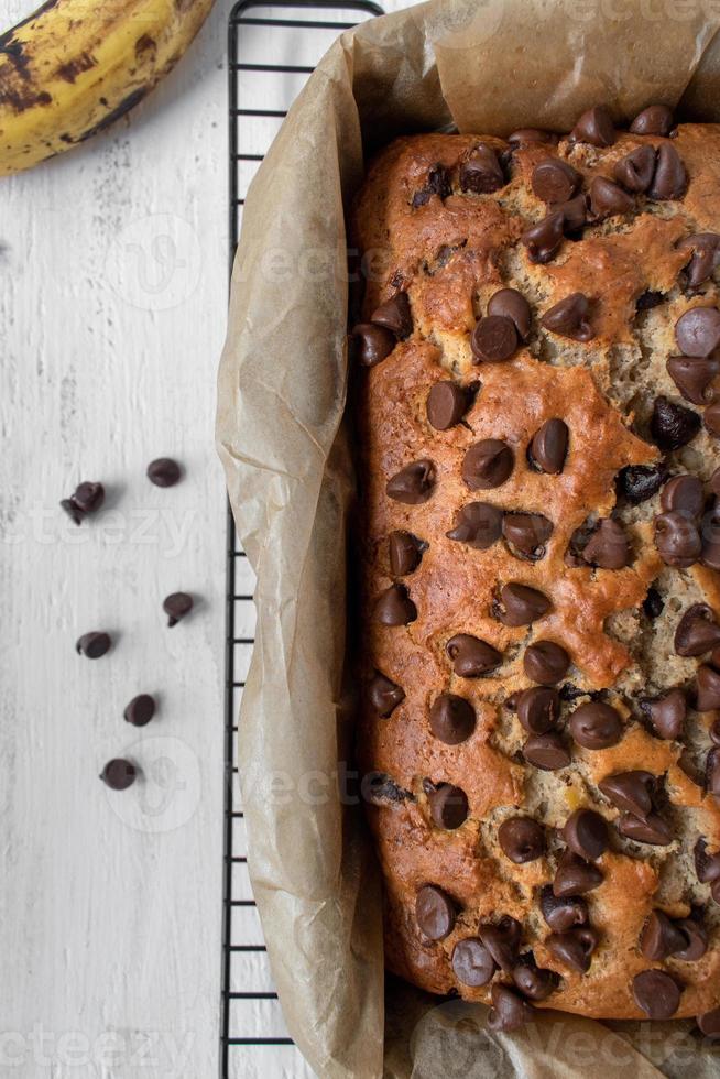 Gebackener Schokoladenchip-Bananenbrotlaib auf Wachspapier flach gelegt foto