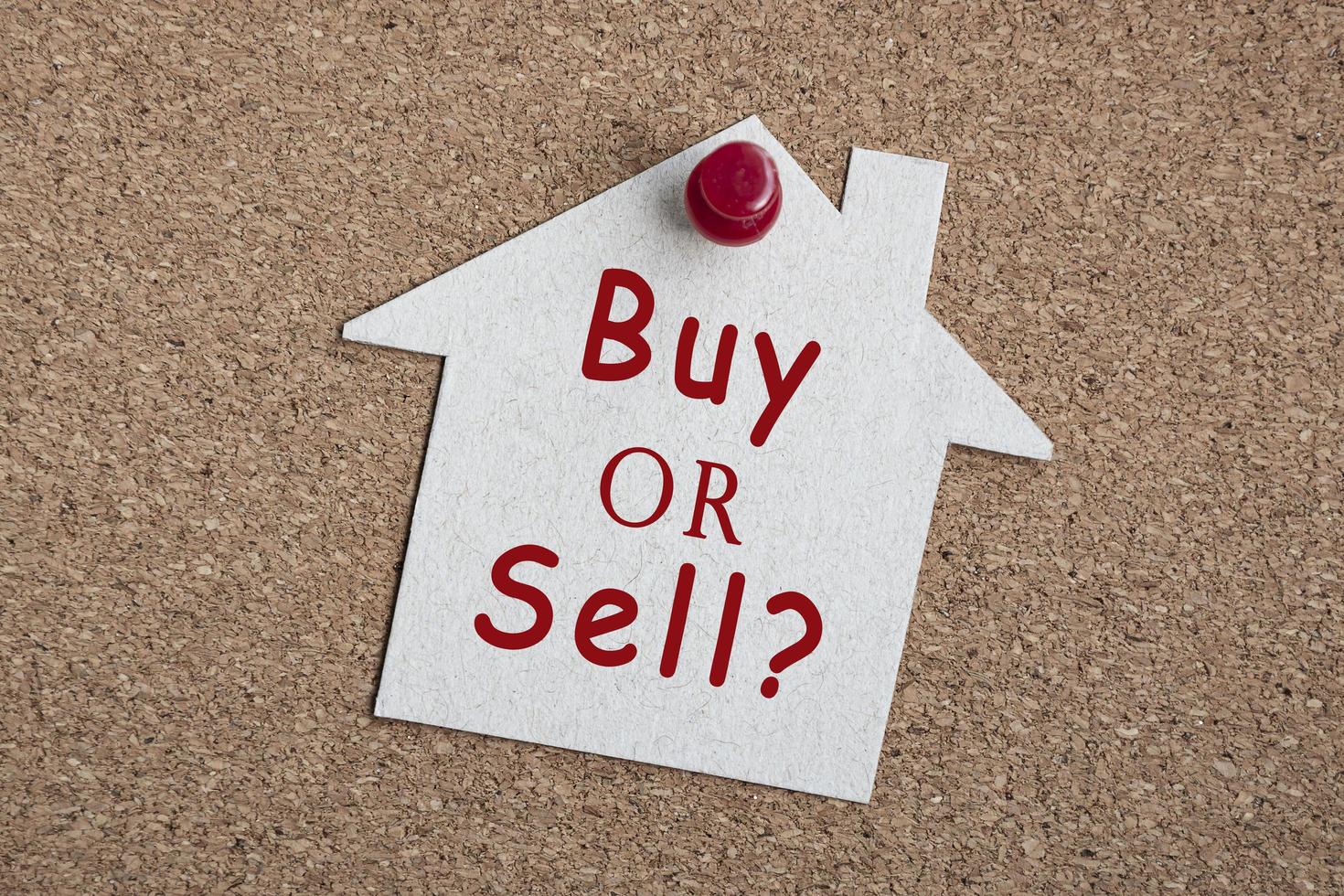 Kauf- oder Verkaufsfrage zum Papierhausmodell. Immobilieninvestitionskonzept foto