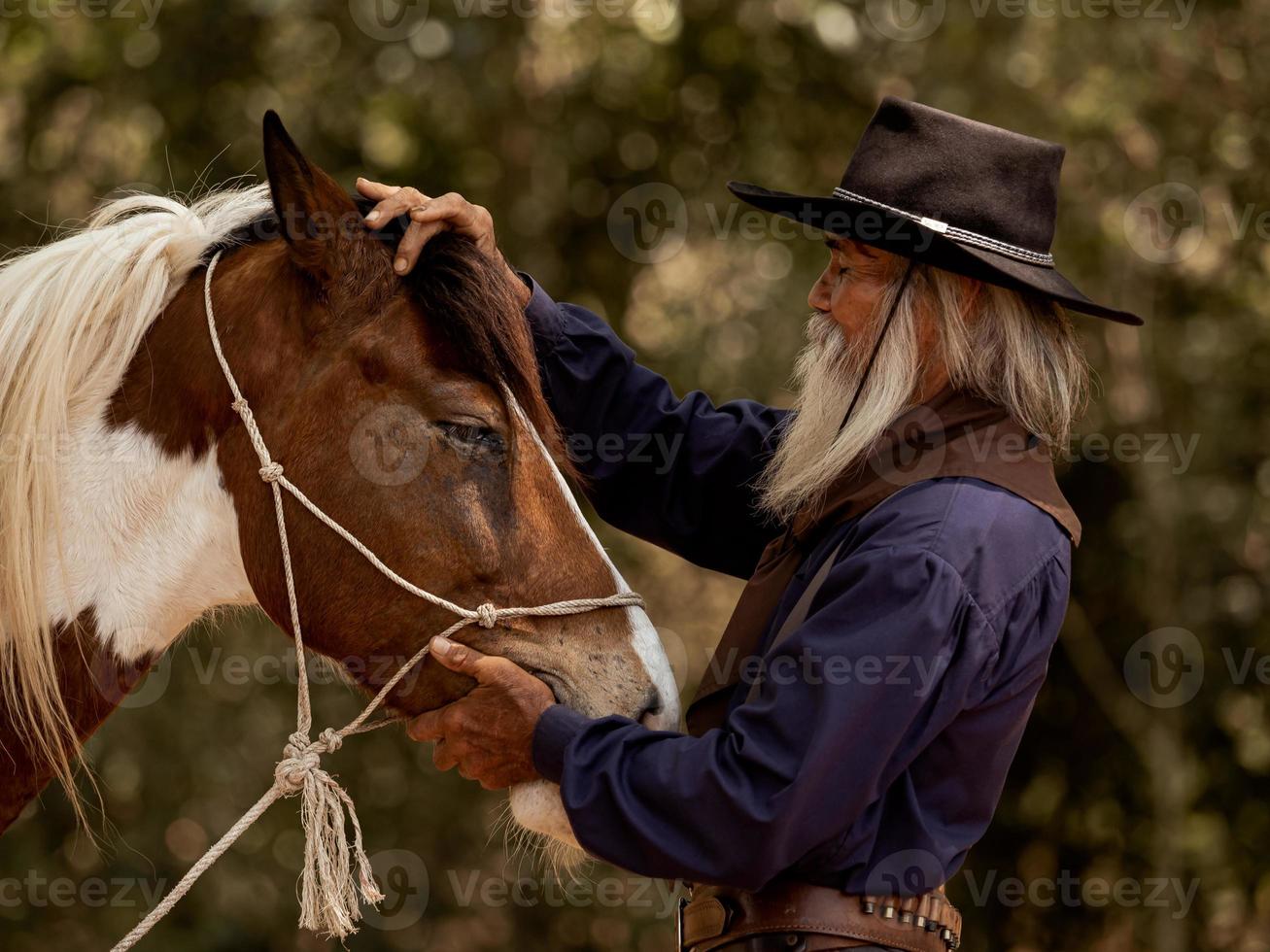 Cowboy berührt das Pferd mit Liebe foto