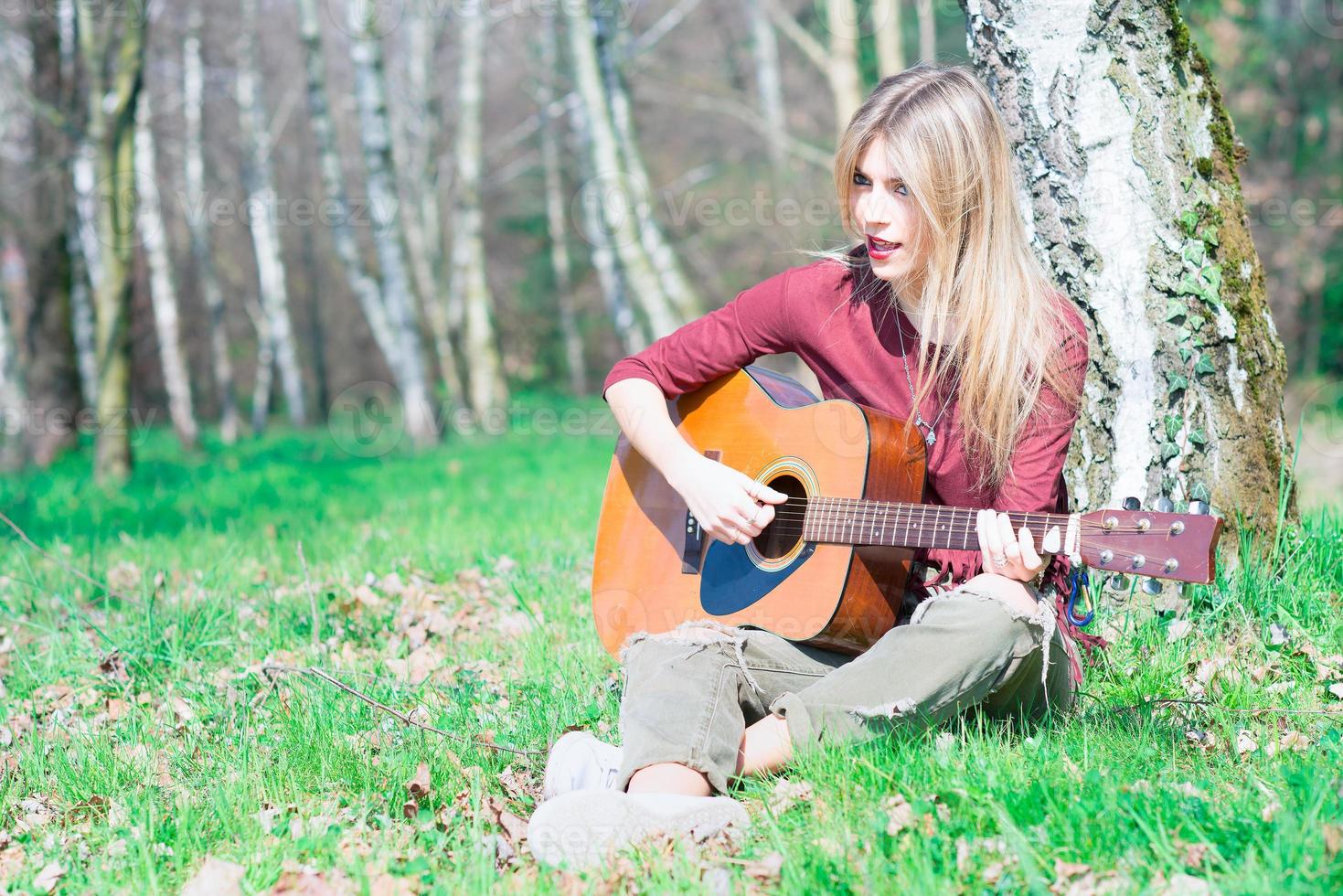 Blondes Mädchen spielt Gitarre foto