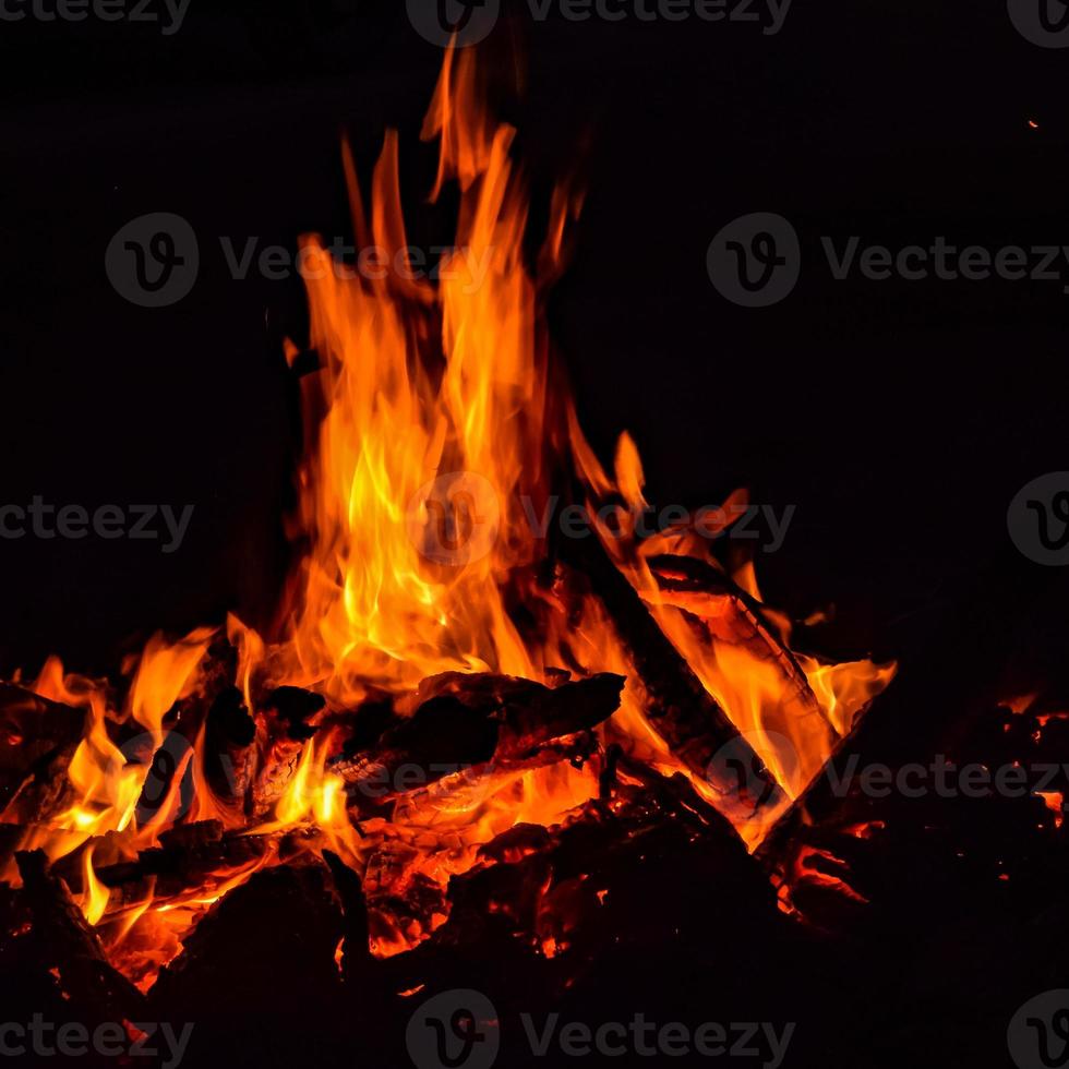 feuerflammen auf schwarzem hintergrund, lodernder feuerflammentexturhintergrund, schön, das feuer brennt, feuerflammen mit holz und kuhdunglagerfeuer foto