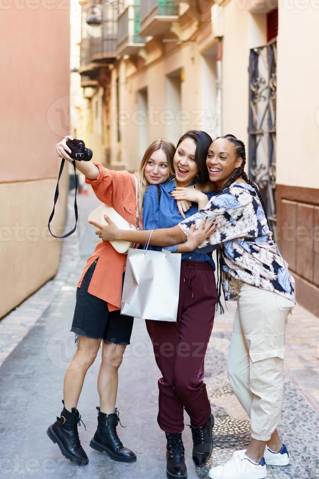 positive gemischtrassige frauen, die selfie auf fotokamera nehmen foto