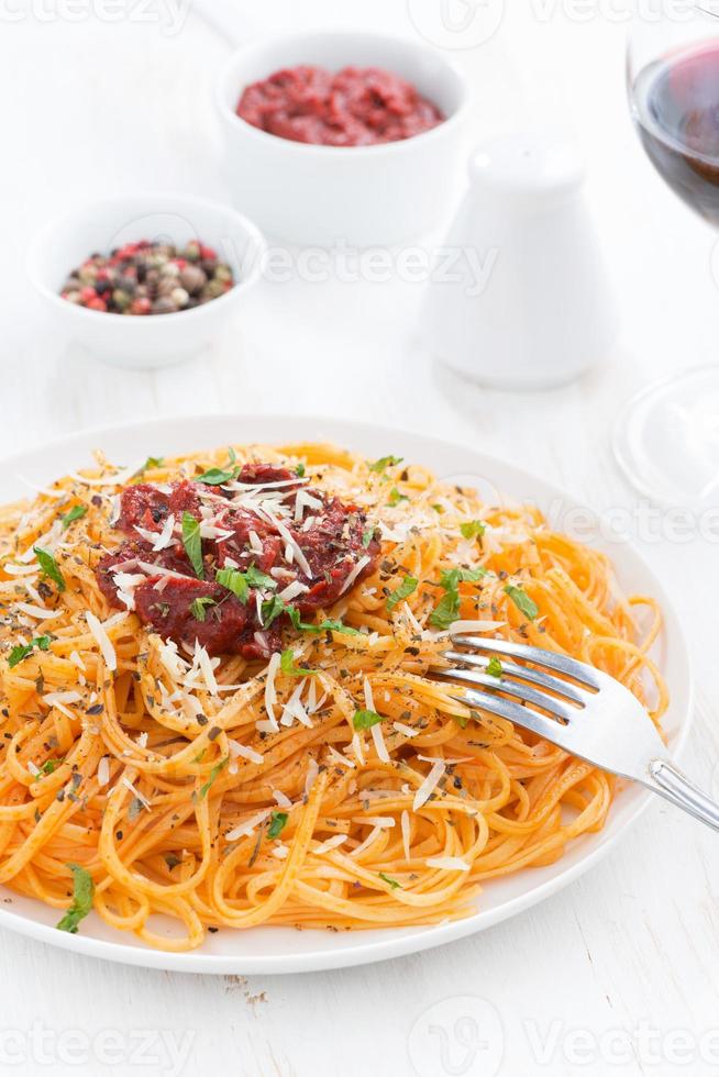 Spaghetti mit Tomatensauce und Parmesan auf Teller foto