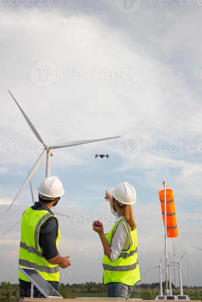 ingenieurteam, das im windturbinenpark arbeitet. erneuerbare energie mit windgenerator durch alternatives energiekonzept. foto
