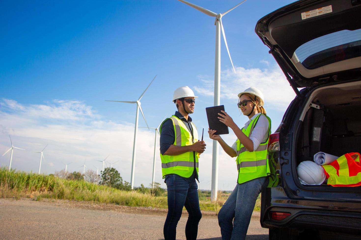 ingenieurteam, das im windturbinenpark arbeitet. erneuerbare energie mit windgenerator durch alternatives energiekonzept. foto