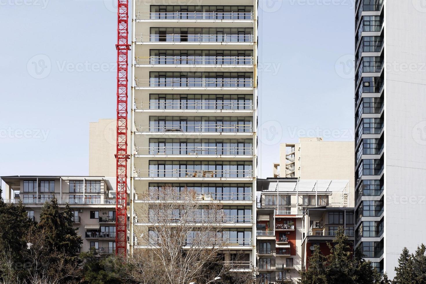 moderne mehrstöckige Wohngebäude und ein roter Hebekran. foto