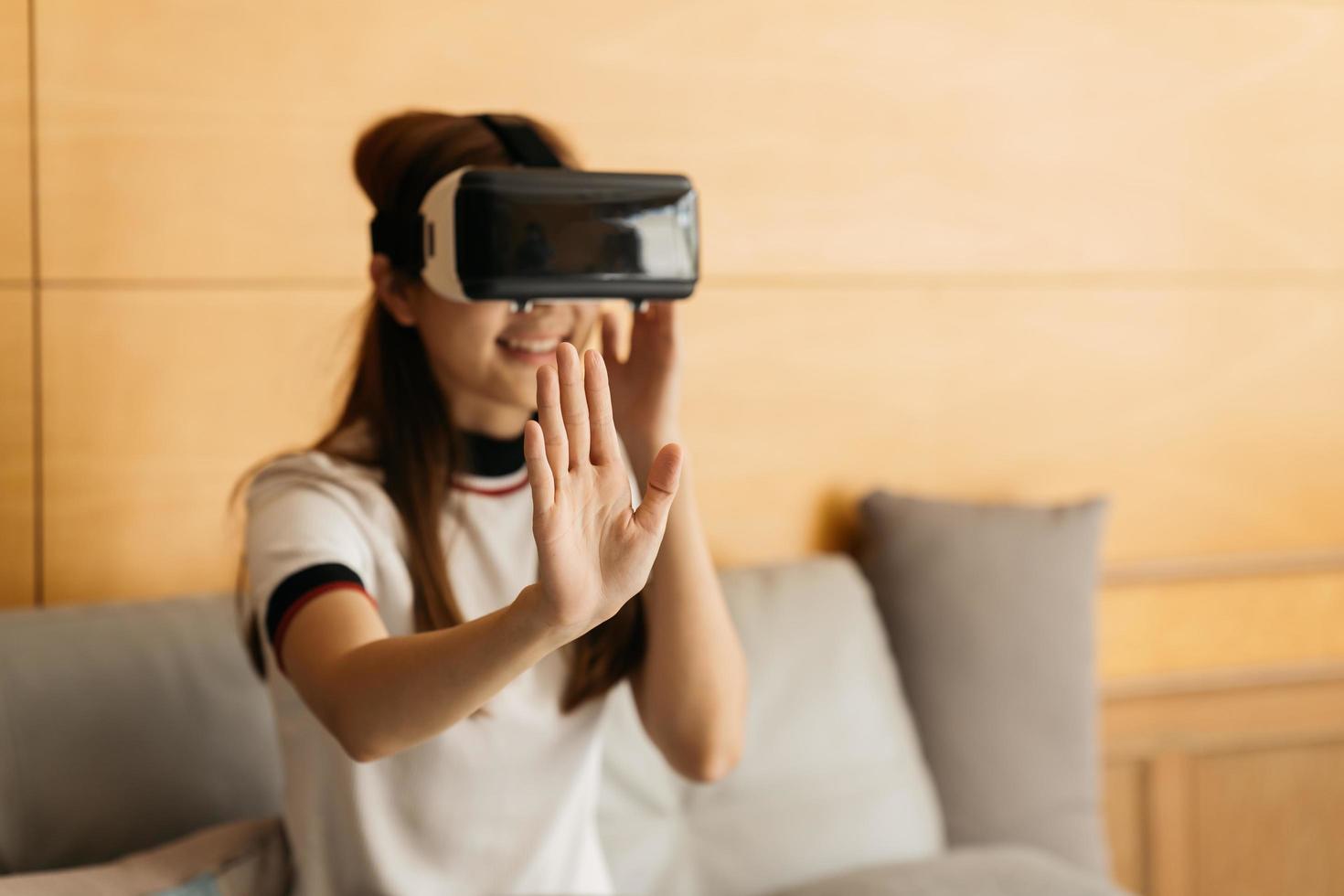 Virtual-Reality-Interaktions-Headset von asiatischer schöner junger Frau, die während der vr-Box berührende Luft trägt, um zukünftige Medien des Spielsimulators zu spielen. Technologie digitales futuristisches Innovationsgerätekonzept foto