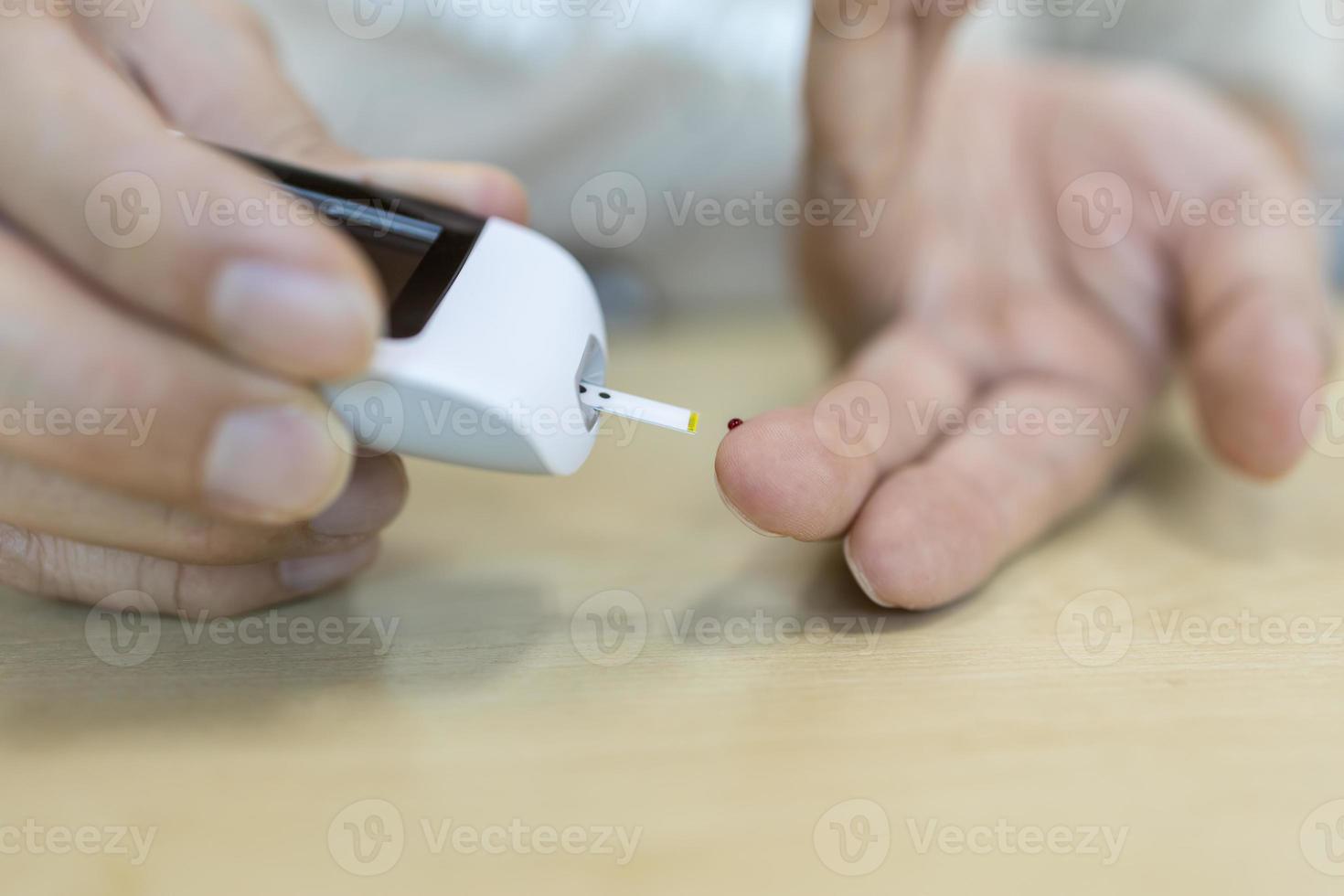 Nahaufnahme von Menschenhänden mit Blutzuckermessgerät am Finger, um den Blutzuckerspiegel zu überprüfen. verwendung als medizin-, diabetes-, glykämie-, gesundheits- und personenkonzept. foto