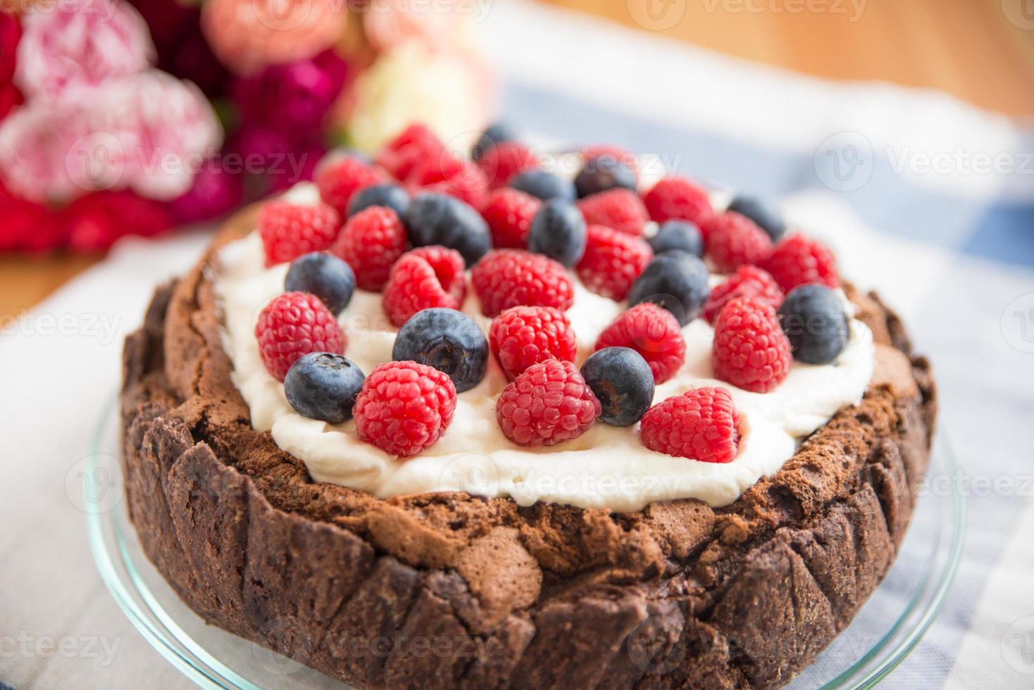 Schokoladenkuchen mit Sahne und gemischten Beeren foto