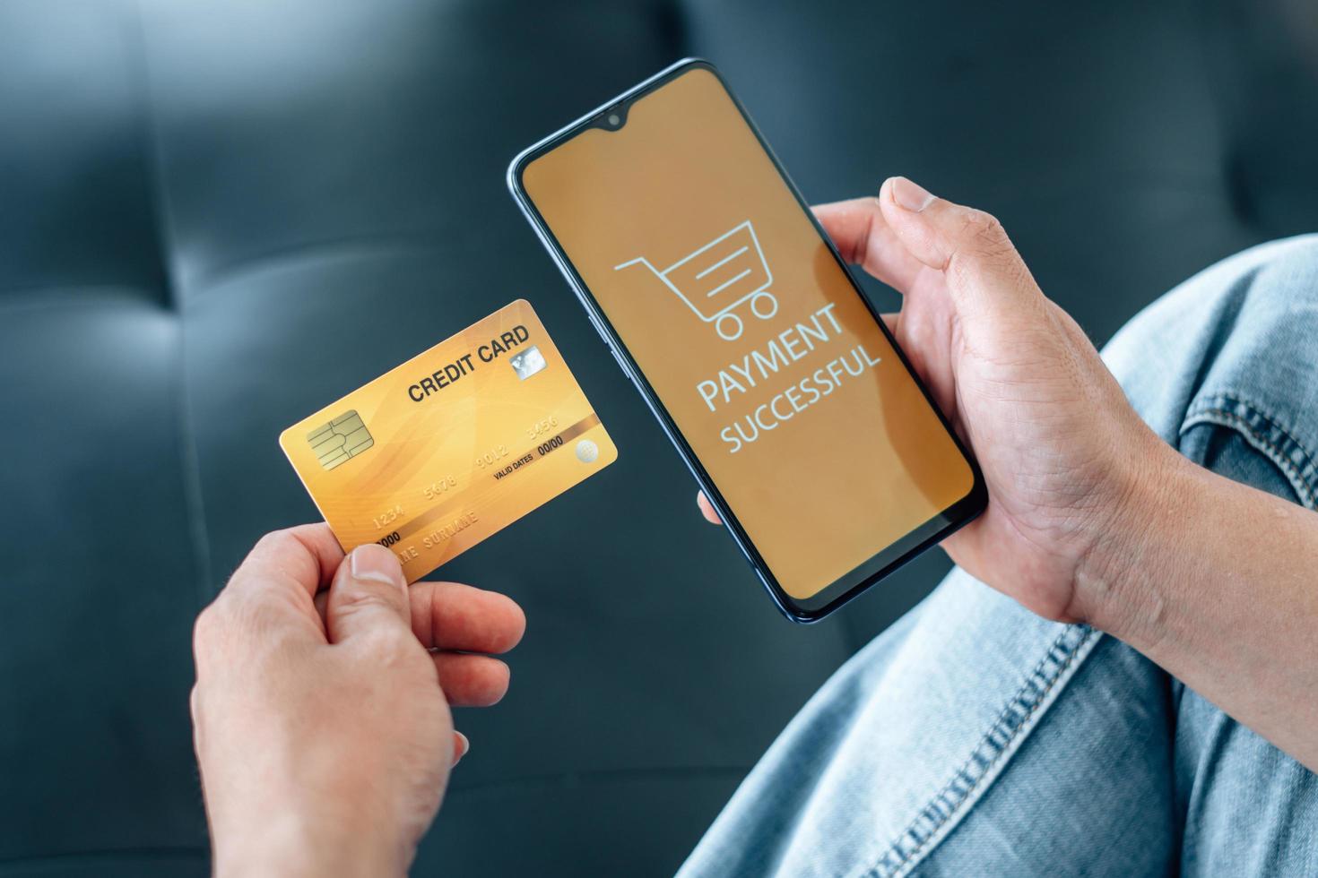 Online-Zahlung, Internet-Banking und Online-Shopping-Konzept. Geschäftsmann hält Kreditkarte und verwendet Smartphone-Zahlung erfolgreich auf dem Tisch. foto