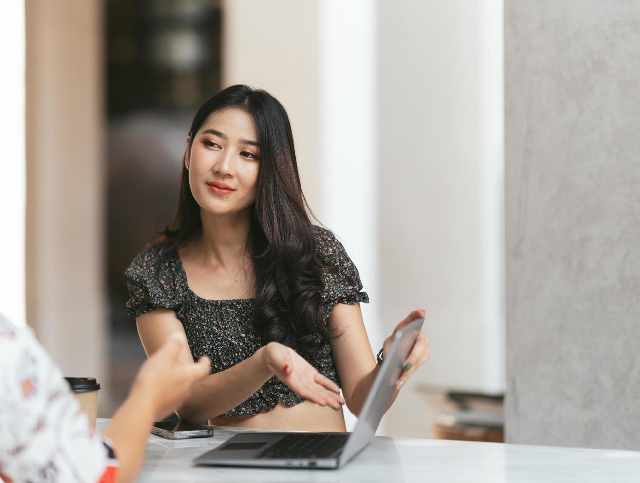 junger asiatischer arbeiter, der sich bei der arbeit über sein produkt unterhält foto