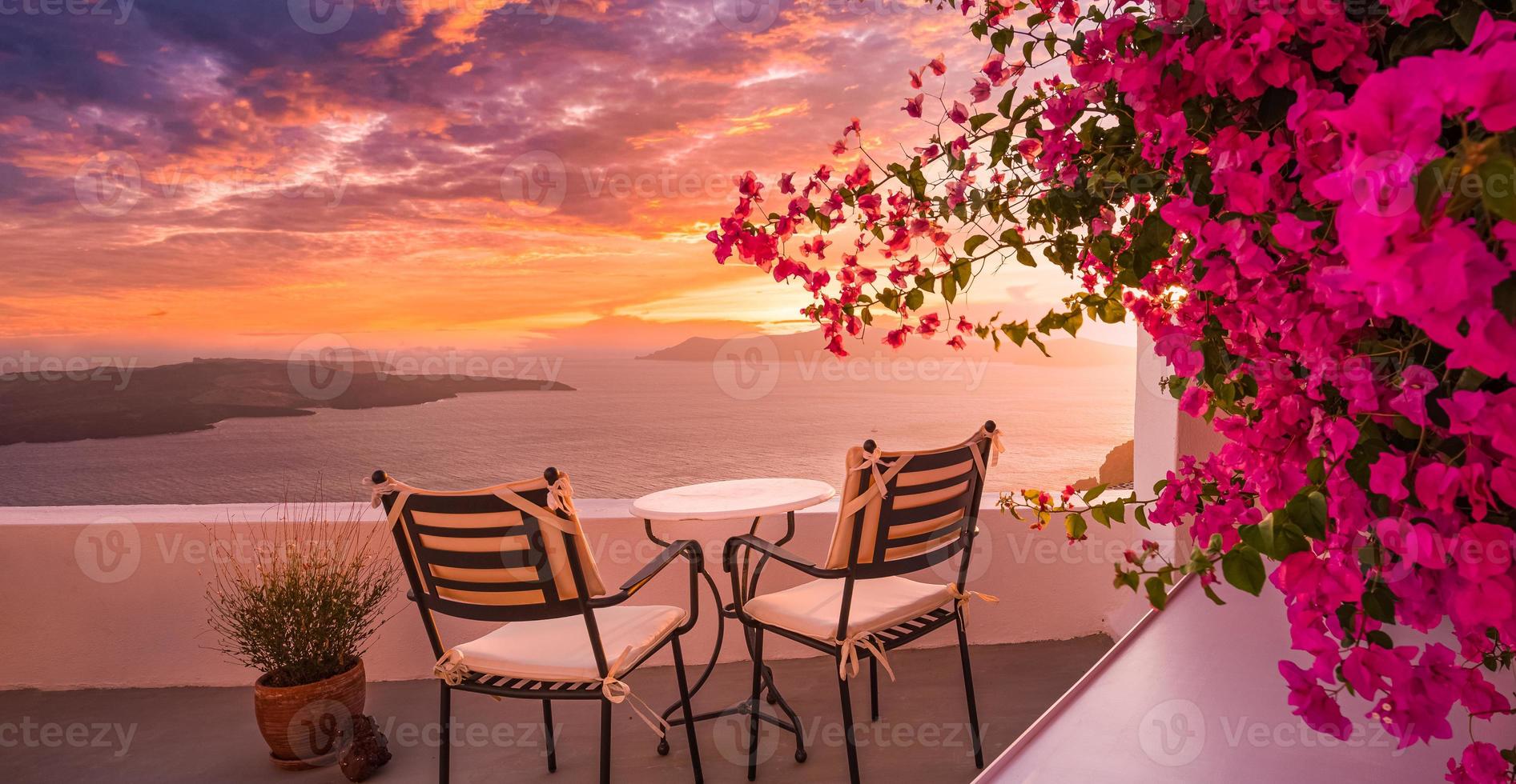 schöne aussicht auf die caldera und genießen der romantischen landschaft sonnenuntergang ägäis, santorini. paar reisen urlaub, flitterwochenziel. Romantik mit Blumen, zwei Stühlen Tisch und Meerblick. Luxuriöser Urlaub foto