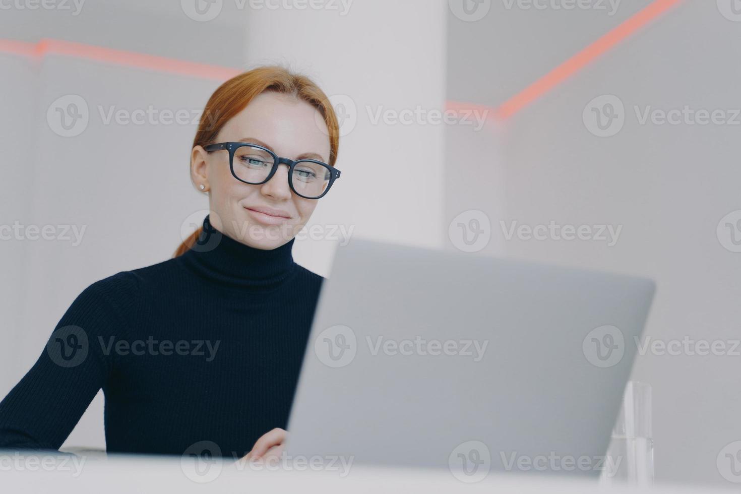 Selbstbewusste junge Frau ist Chefin am Arbeitsplatz im Büro. Manager durchsucht die Informationen. foto