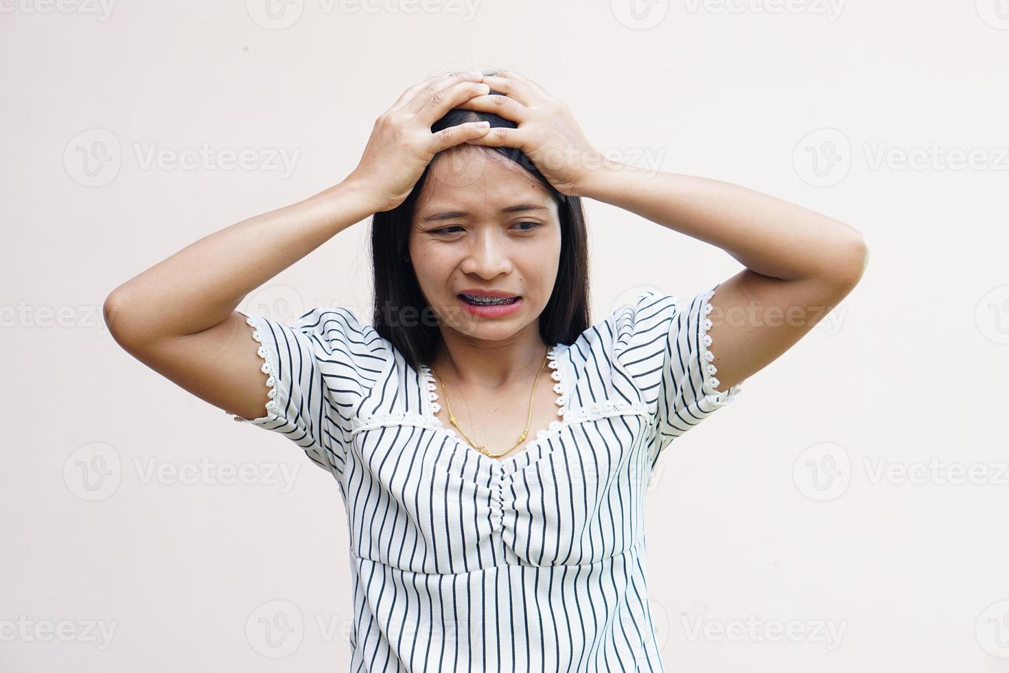 asiatische frauen leiden unter arbeitsstress. lege die Hand auf deinen Kopf foto