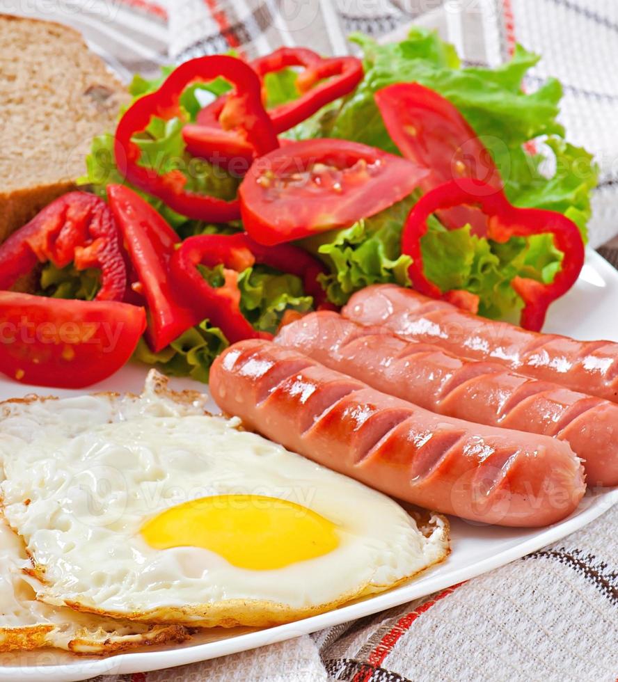 englisches Frühstück - Würstchen, Eier, Bohnen und Salat foto