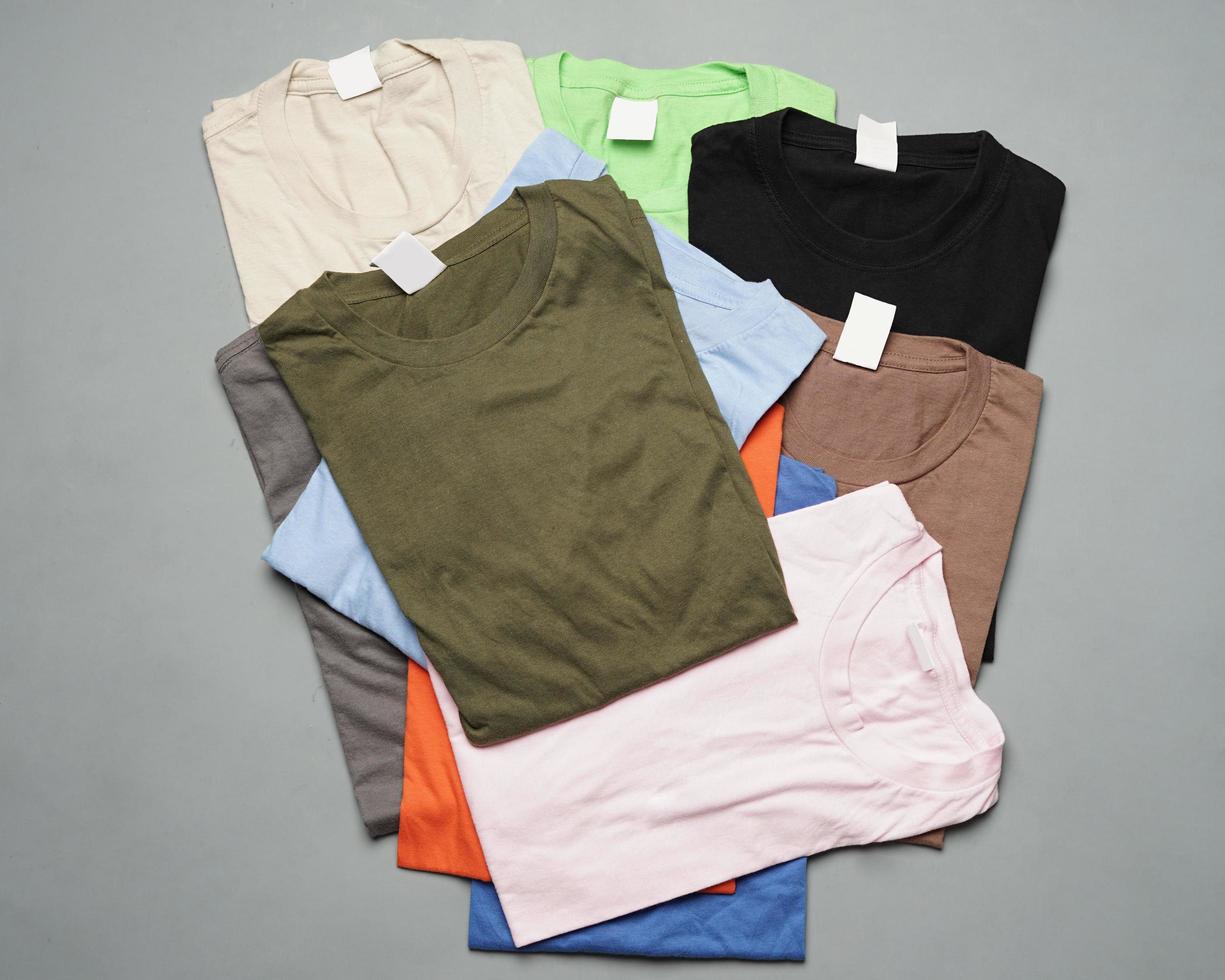 ordentlich arrangierte Stapel schlichter Baumwoll-T-Shirts. schlichte bunte T-Shirts, die zu Designmodellen verarbeitet werden können. T-Shirts sind sauber ohne Branding. leere T-Shirt-Vorlage für Männer. Fokusunschärfe. eid foto