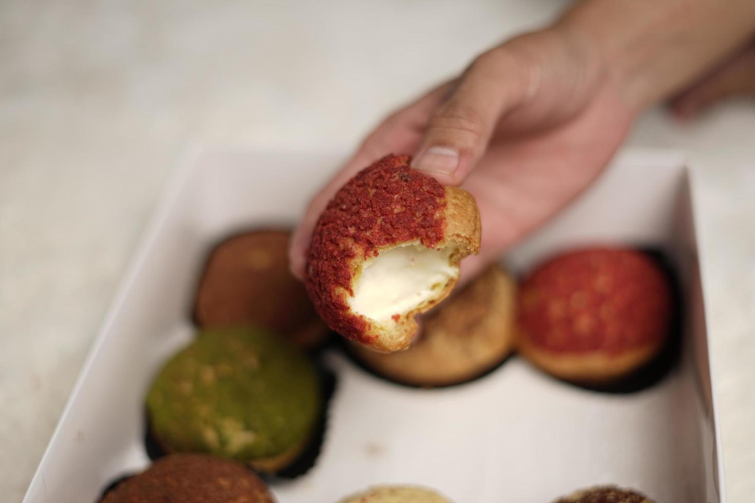 Craquelin Choux ist ein japanischer Eclair mit knusprigem Überzug, der süß und cremig schmeckt. Windbeutel mit verschiedenen Aromen von Fla, Vanille, Schokolade, Matcha. eid Körbe oder Pakete. Fokusunschärfe. foto