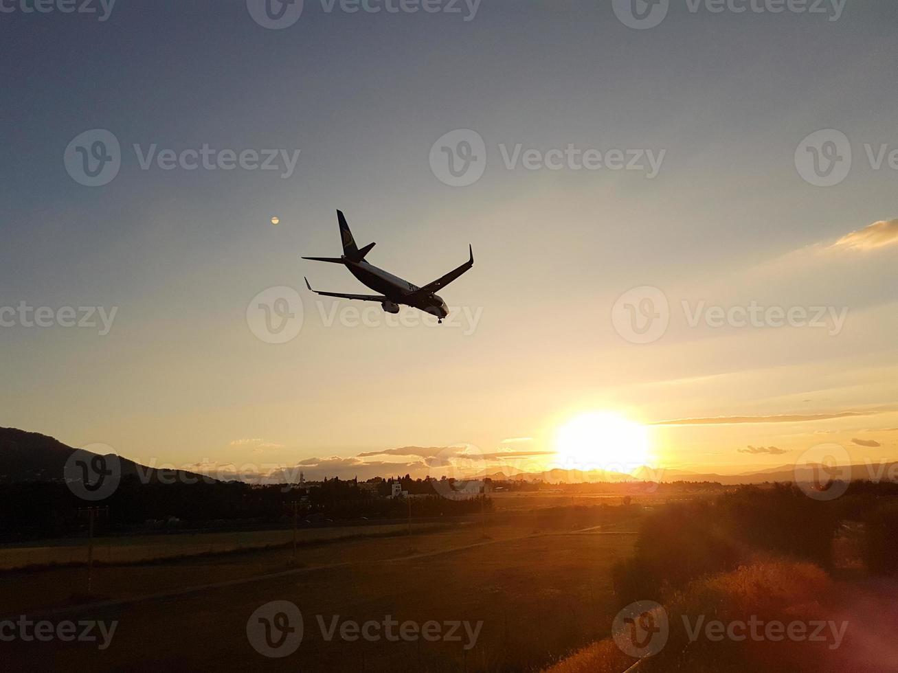 Flugzeug nähert sich der Landung in einem Sonnenuntergang foto