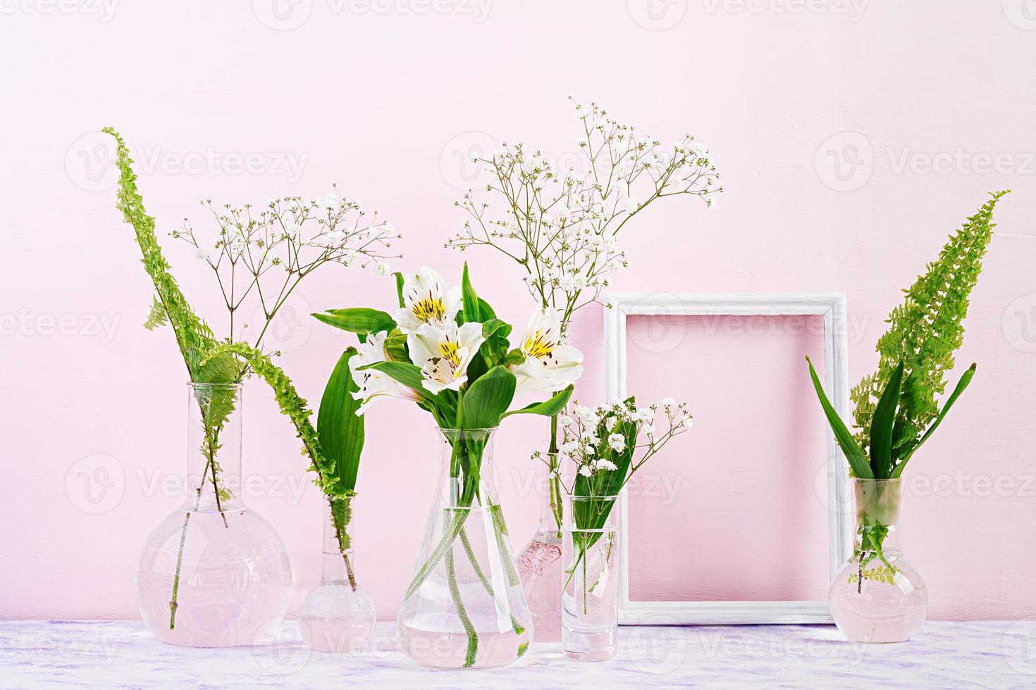 blumen und pflanzen in flasche mit rahmen. schöner frühlingshintergrund mit blumen in der vase. foto