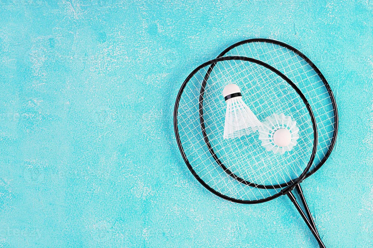 Federball und Badmintonschläger auf blauem Hintergrund. Ansicht von oben foto