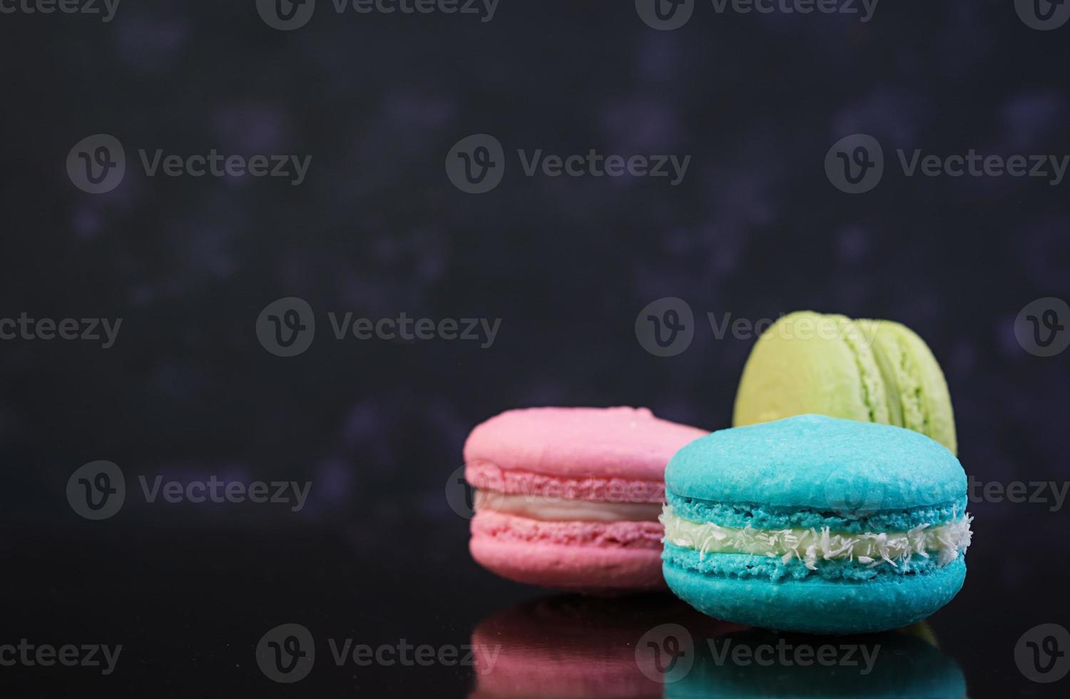 Köstliche bunte Macaron-Kuchen auf dunklem Hintergrund foto