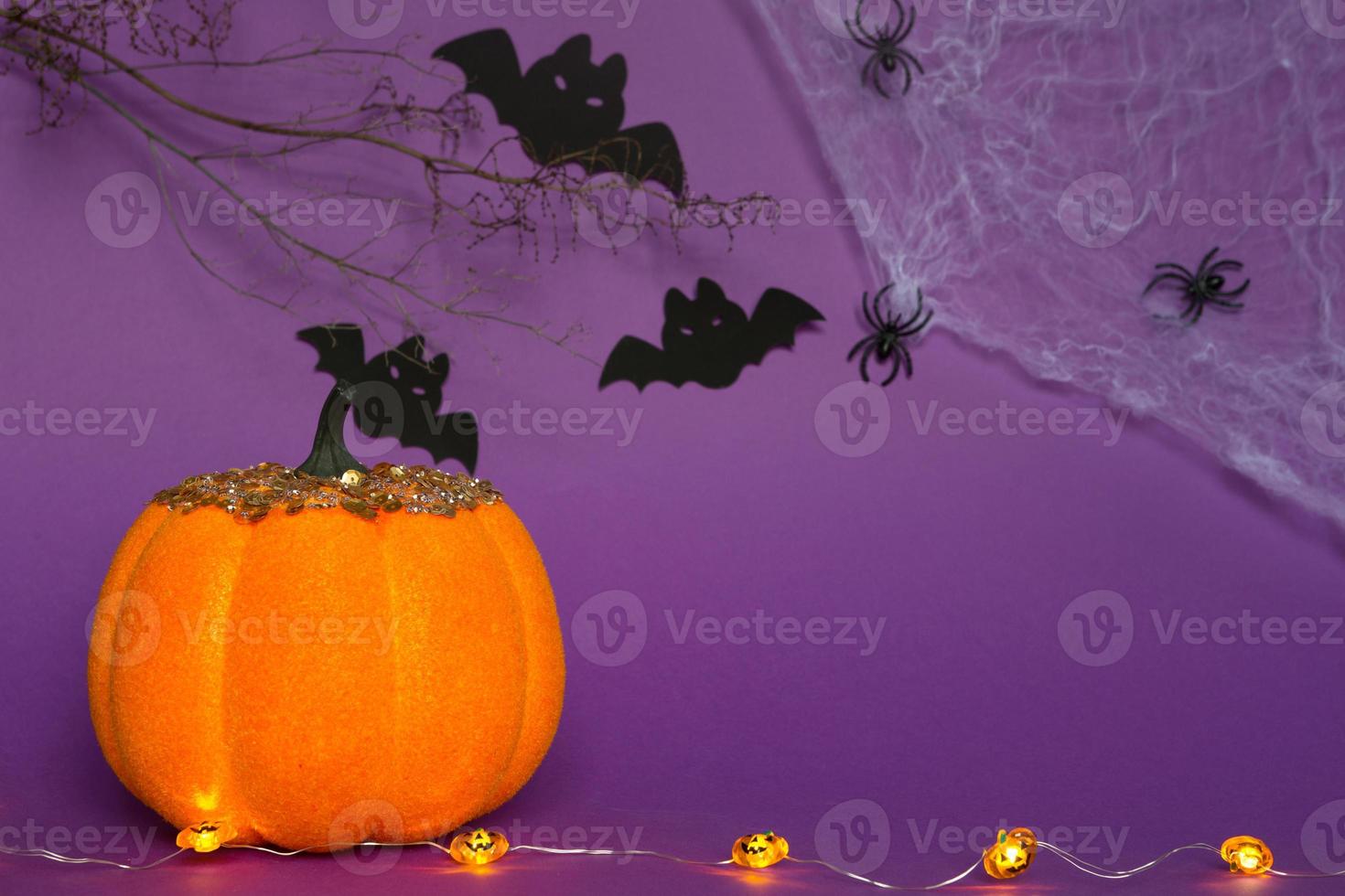 Halloween-Hintergründe aus weißen, orangefarbenen und goldenen Kürbissen, Spinnen und schwarzen Fledermäusen auf einem violetten Hintergrund mit Spinnweben und schrecklicher Landschaft. horror und ein gruseliger urlaub mit kopierraum foto