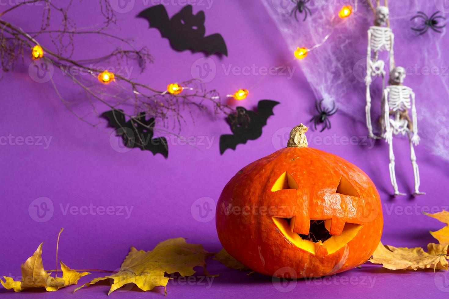 Halloween-Hintergründe von Jack-Laternen-Kürbis, Spinnennetz, Skelett an einem Seil, Spinnen und schwarzen Fledermäusen auf violettem Hintergrund mit schrecklicher Landschaft. horror und ein gruseliger urlaub mit kopierraum foto