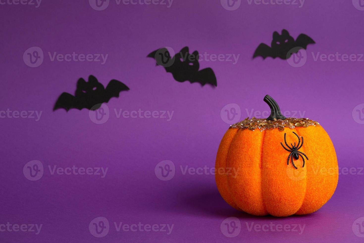 Halloween-Hintergründe aus weißen, orangefarbenen und goldenen Kürbissen, Spinnen und schwarzen Fledermäusen auf einem violetten Hintergrund mit Spinnweben und schrecklicher Landschaft. horror und ein gruseliger urlaub mit kopierraum foto