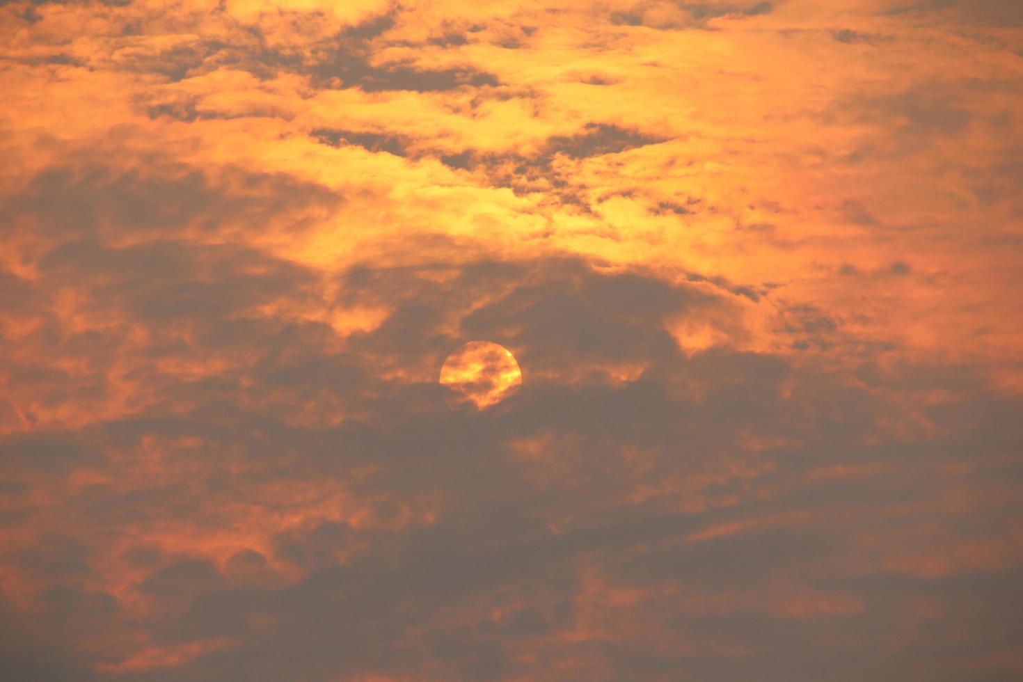 orangefarbenes Licht und Sonnenuntergang am Abend. graue, flauschige wolkenbedeckte sonne. foto